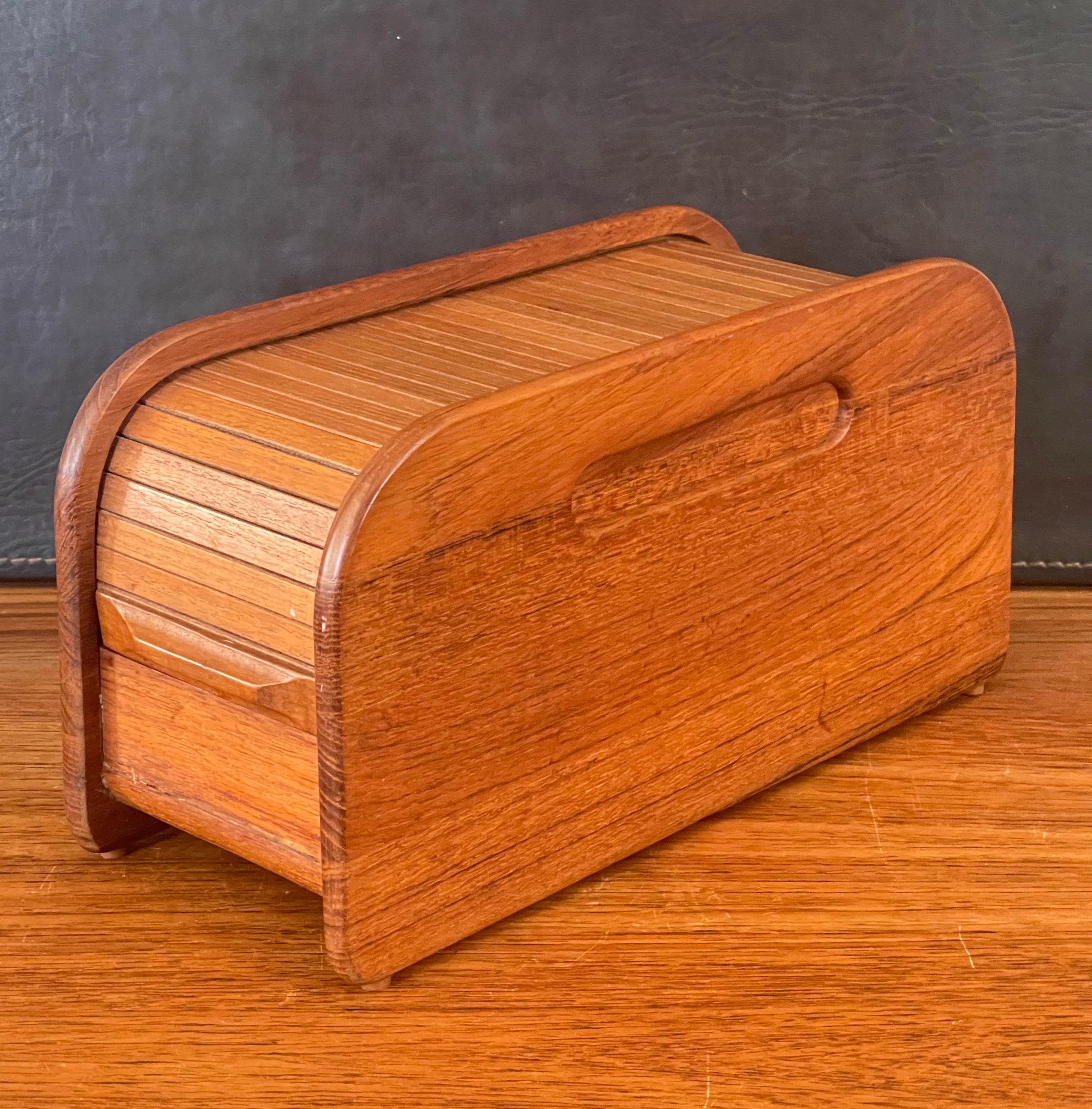 Small Danish modern solid teak tambour door trinket box, circa 1970s. This beautiful well crafted roll top desk box is great for trinkets or storage. The piece is in very good vintage condition and measures 4.75