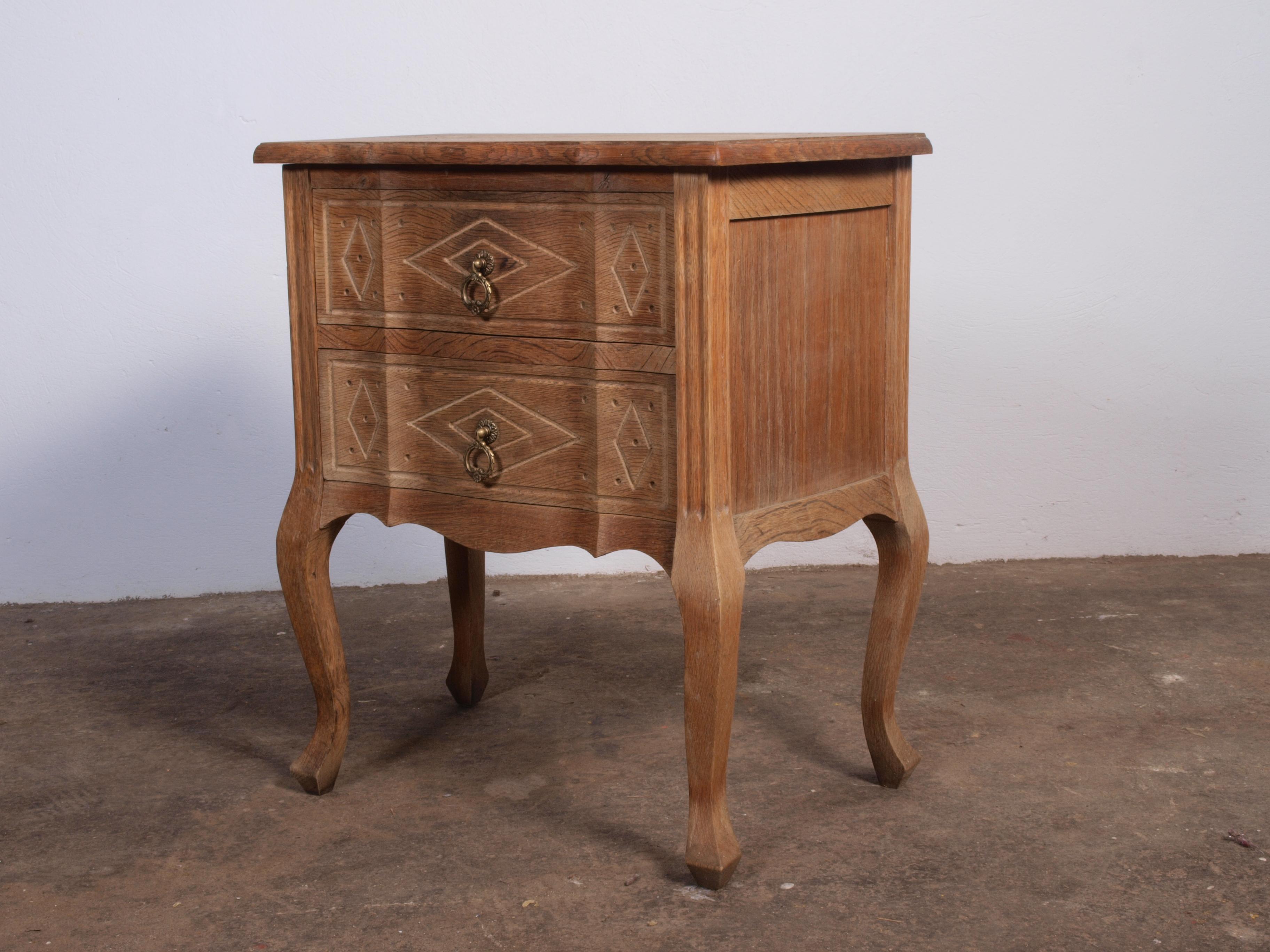 This small vintage Danish oak cabinet is in perfect working condition. It has a beautiful patina and strong lines, with simple and minimalistic design. The legs have an outgoing curve reminiscent of French design, while the wood carvings on the