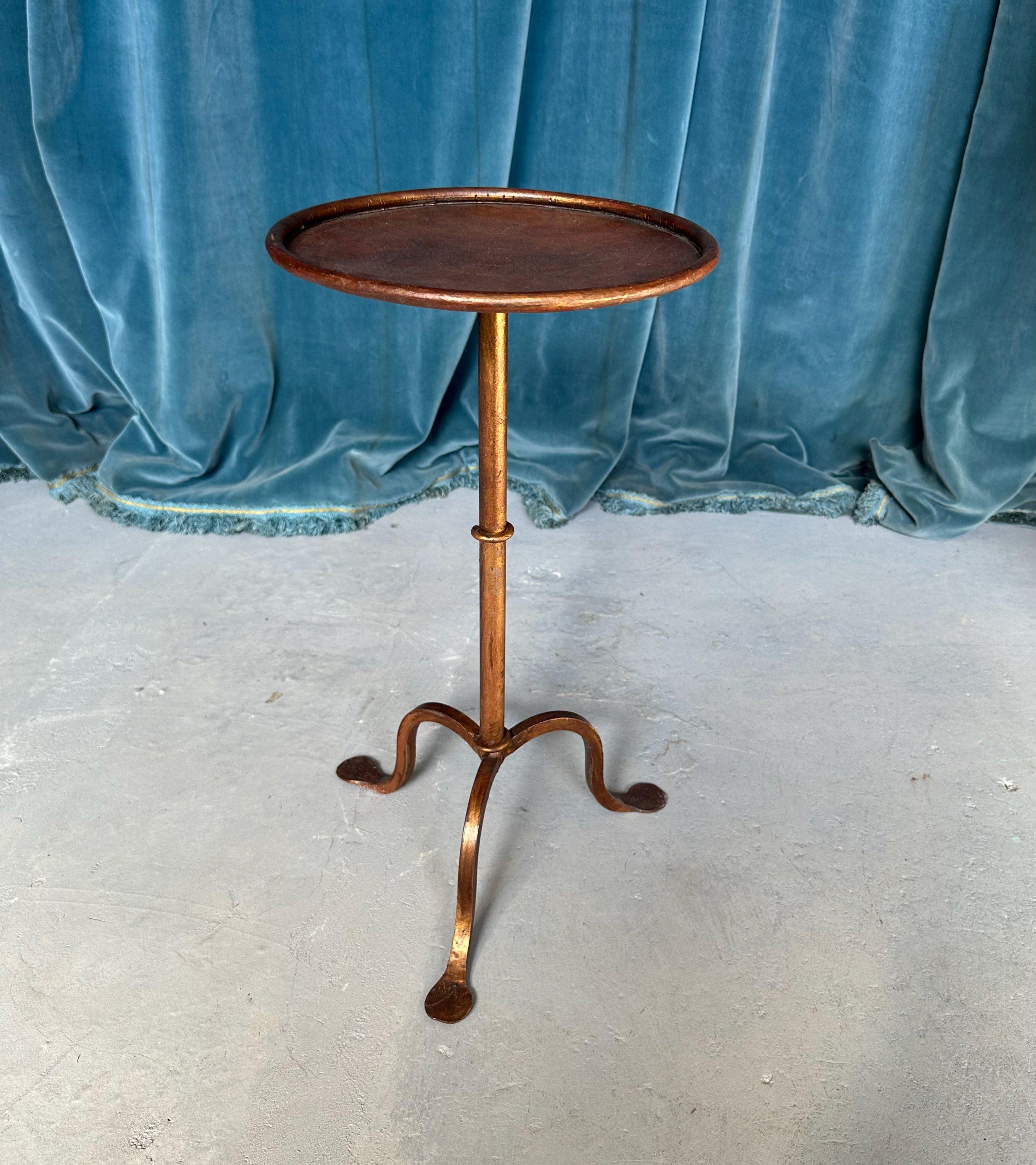 This small iron and metal end table from Spain was recently crafted by skilled artisans using traditional iron-working techniques. Based on a vintage 1950s design, it features a sturdy tripod base with hammered curved legs and a central ring detail