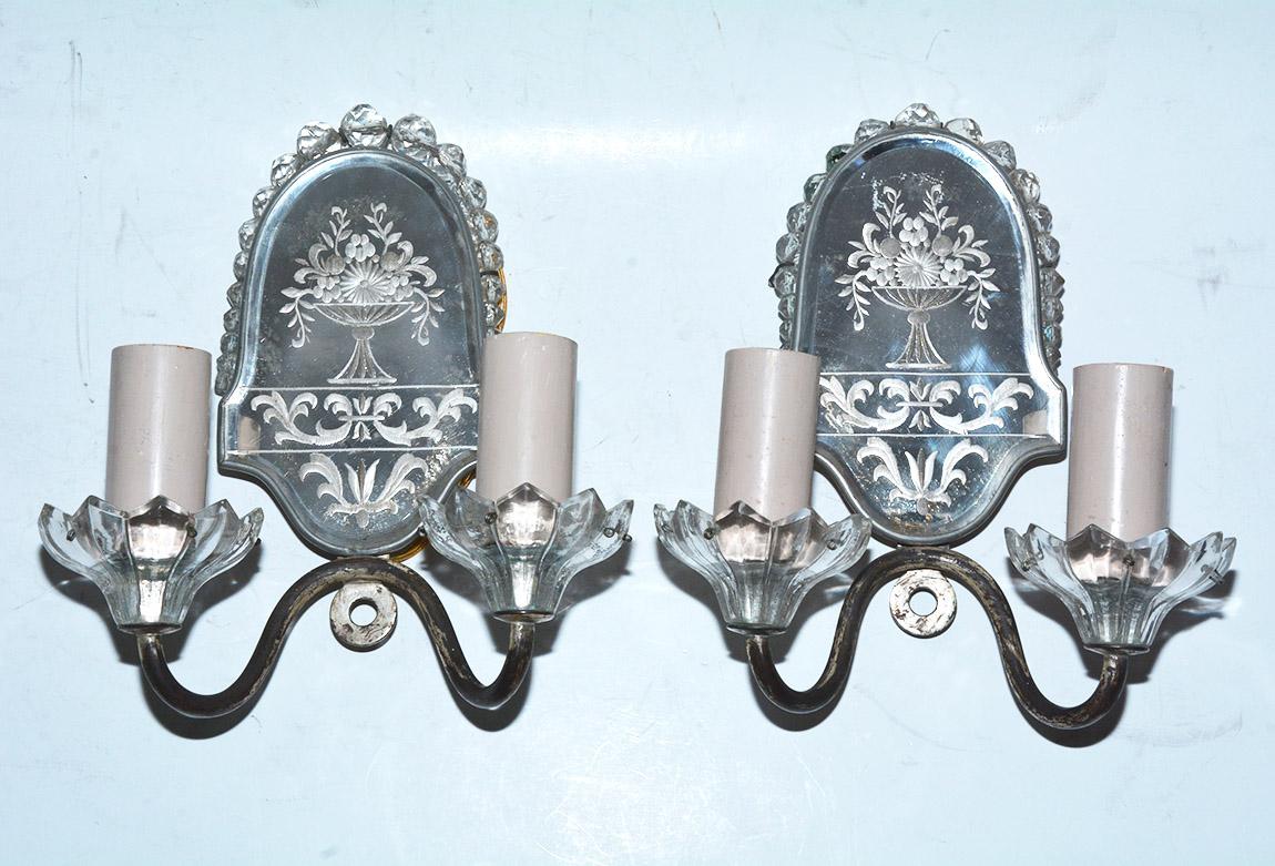 Pair of elegant mirrored wall sconces with etched-under-glass design of flowers in urns and scrollwork and rows of graduated crystal beads. Great for bathroom or powder room. Electrified for USA, using regular bulbs. Should be rewired for flame
