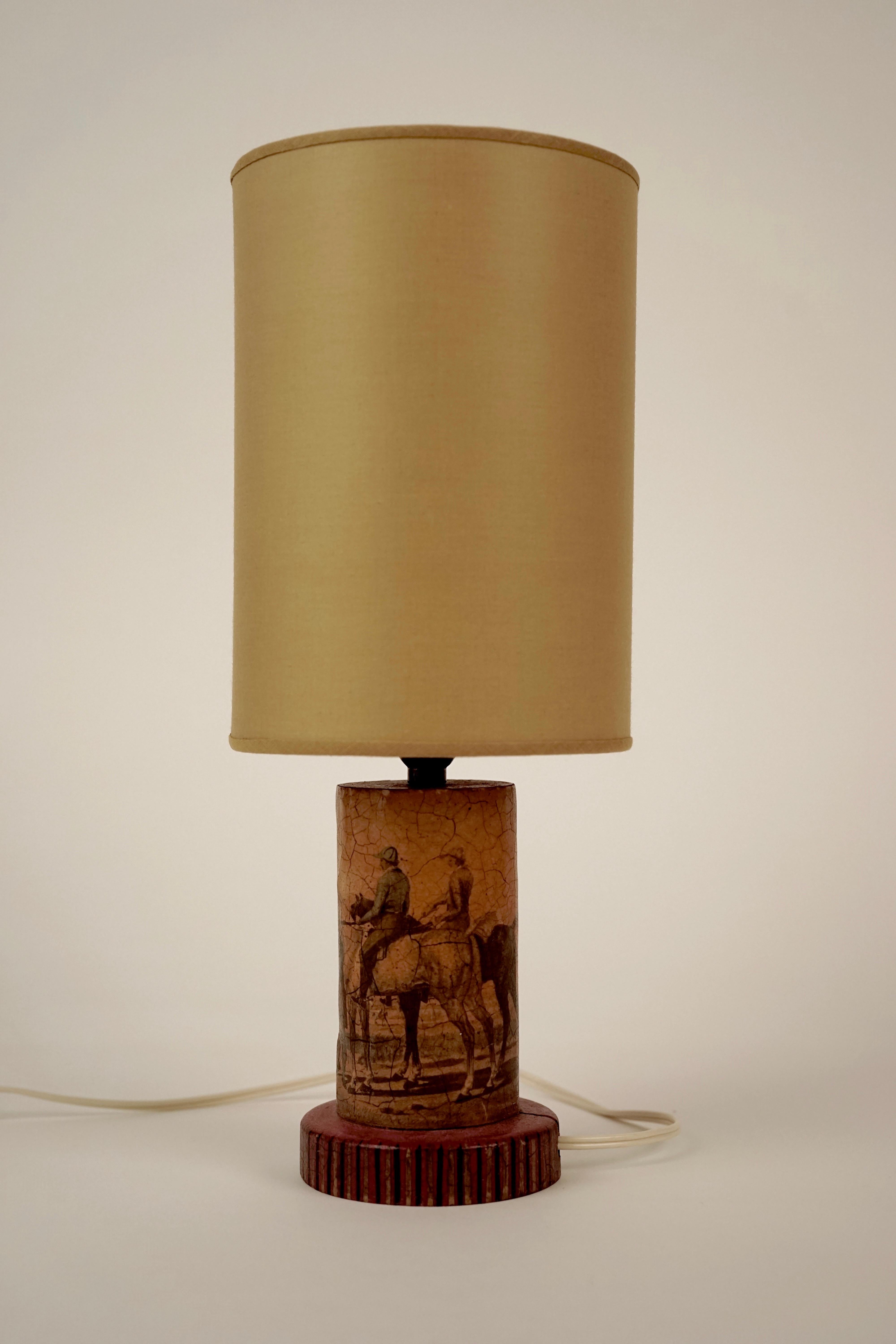 Lovely wooden lamp with découpage motive: English countryside with riders. 
The details on the base are hand painted. The shade is new.
The base has a crack from the natural movement of the wood.
  