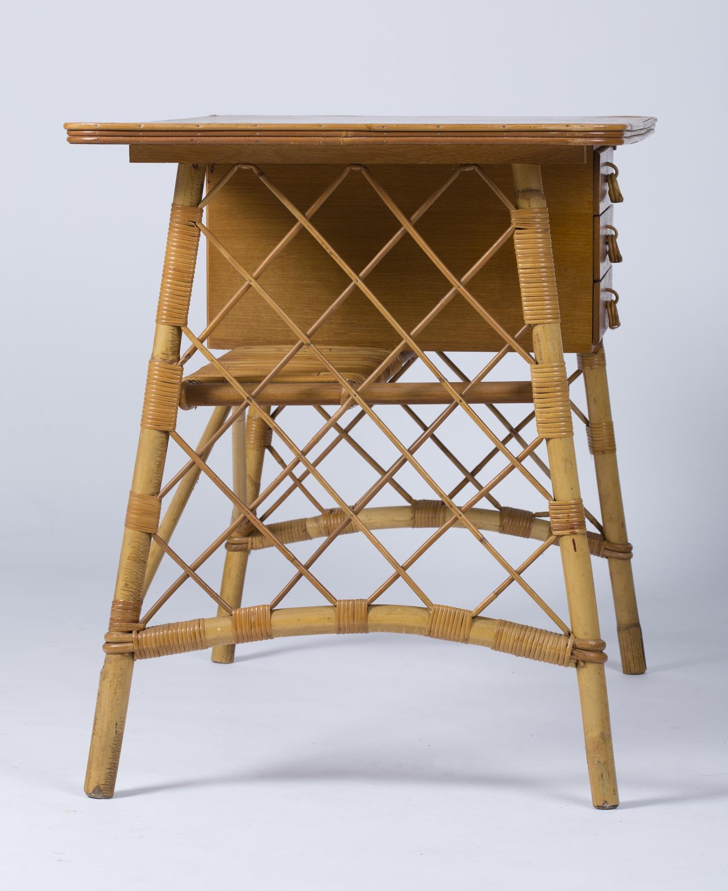 Small desk, stool and wastepaper basket in rattan by Louis Sognot (1892-1970).
Rattan desk with a box suspended from the right-hand side of the tabletop, equipped with three drawers. The sides openworked in rattan trellis.
France circa 1950.