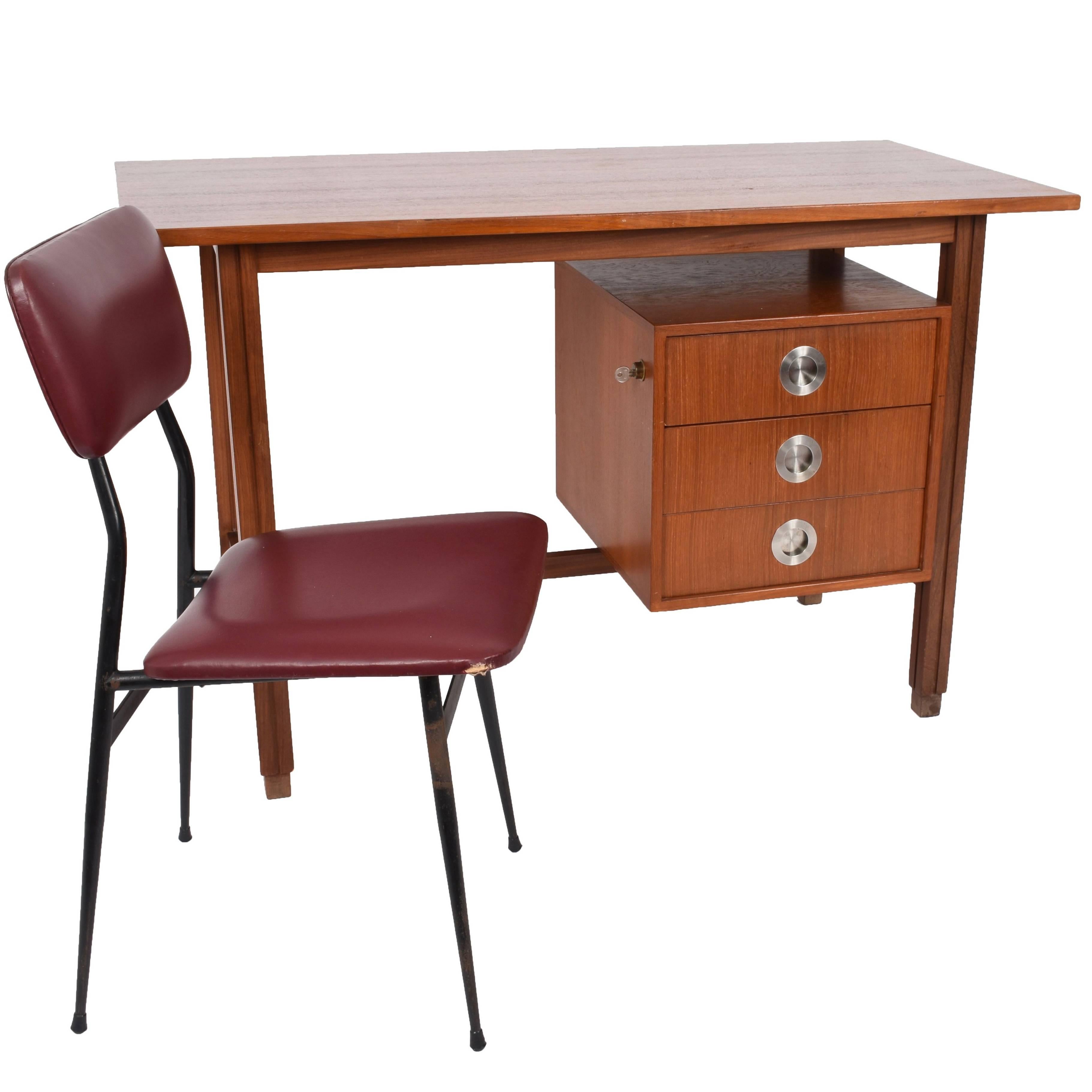 Small teak desk with brushed steel handles. Lateral lock with original key. Beautiful piece and in excellent condition. The chair is complimentary and is remarkably beautiful (has signs of wear but is beautiful) in iron covered in sky.