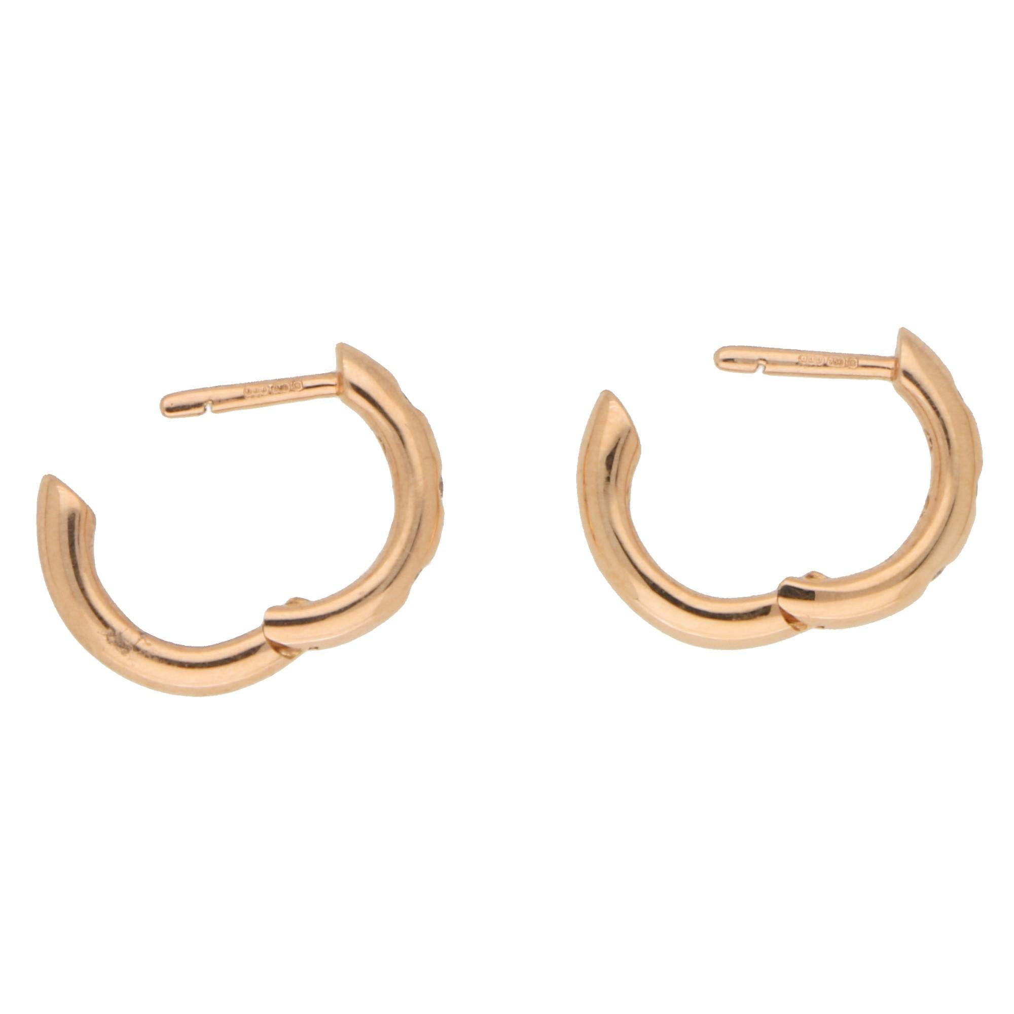 A super pair of everyday diamond huggy hoop earrings set in 18k rose gold.

Each hoop earring is evenly rub-over set with 3 round brilliant cut diamonds secured with a post and click shut fitting. Due to their size these earrings would make an ideal