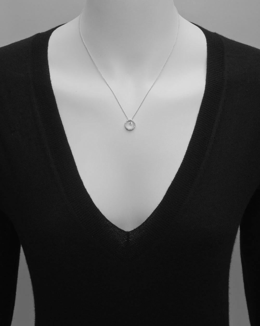 Diamond open circle drop pendant in 18k white gold, with a single round diamond dangling accent at center. 0.38 total carats of round diamonds (G-H color, SI1-SI2 clarity). Pendant suspended from a fine 18