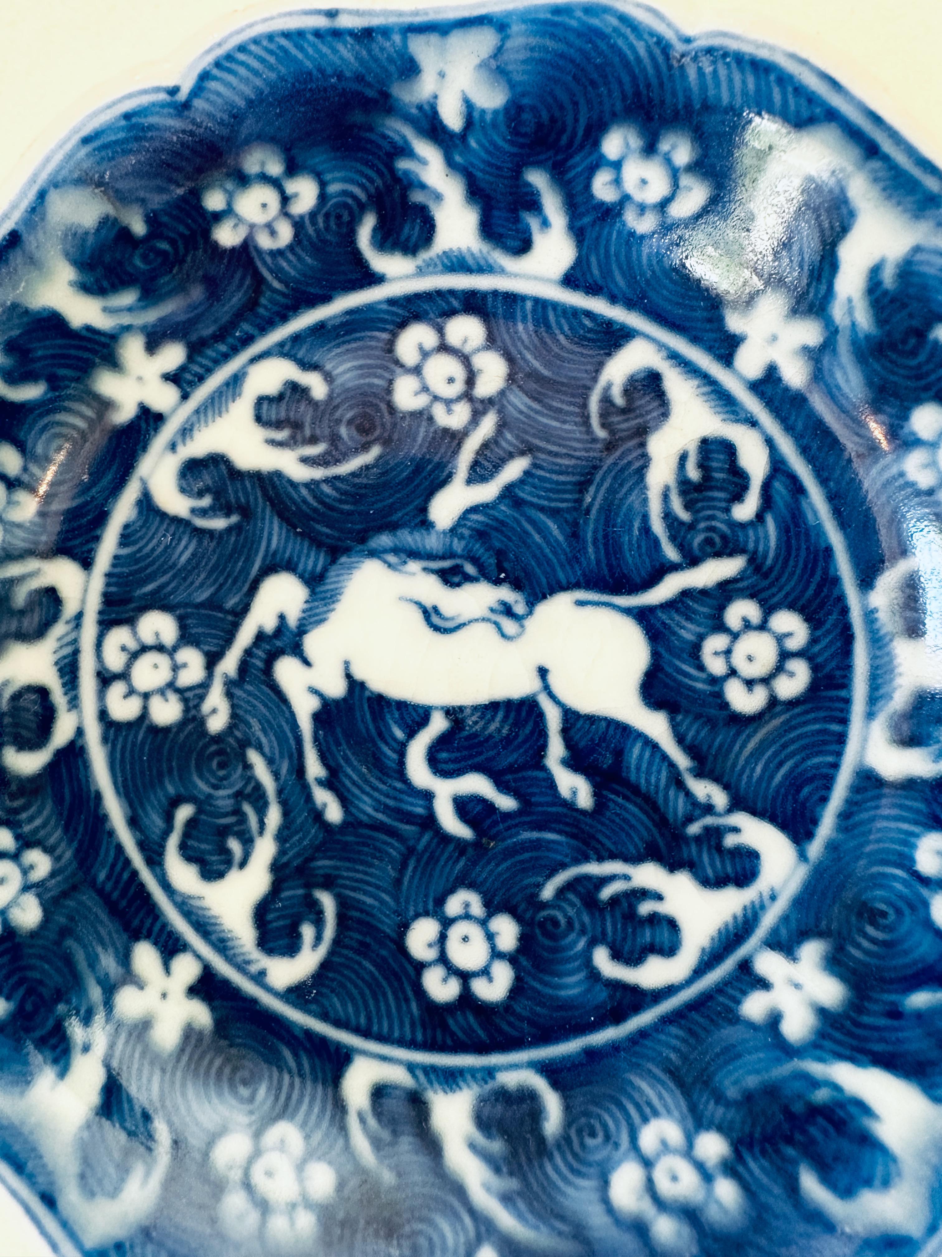 Small blue and white dish from Hatcher Cargo decorated with a flying horse on a background of white florets on a blue wave pattern ground, mid 17th century. 

This dish was part of a hoard recovered by Captain Michael Hatcher from the wreck of a