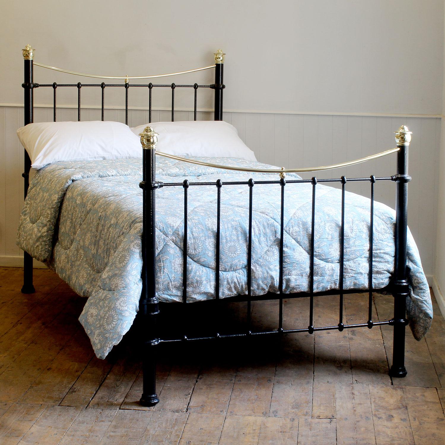 A small double Victorian cast iron and brass bedstead finished in black with curved brass top rails, brass cap collars and simple castings.

This bed accepts a small double size 4ft wide (48 inch or 120cm) base and mattress. 

The price includes a