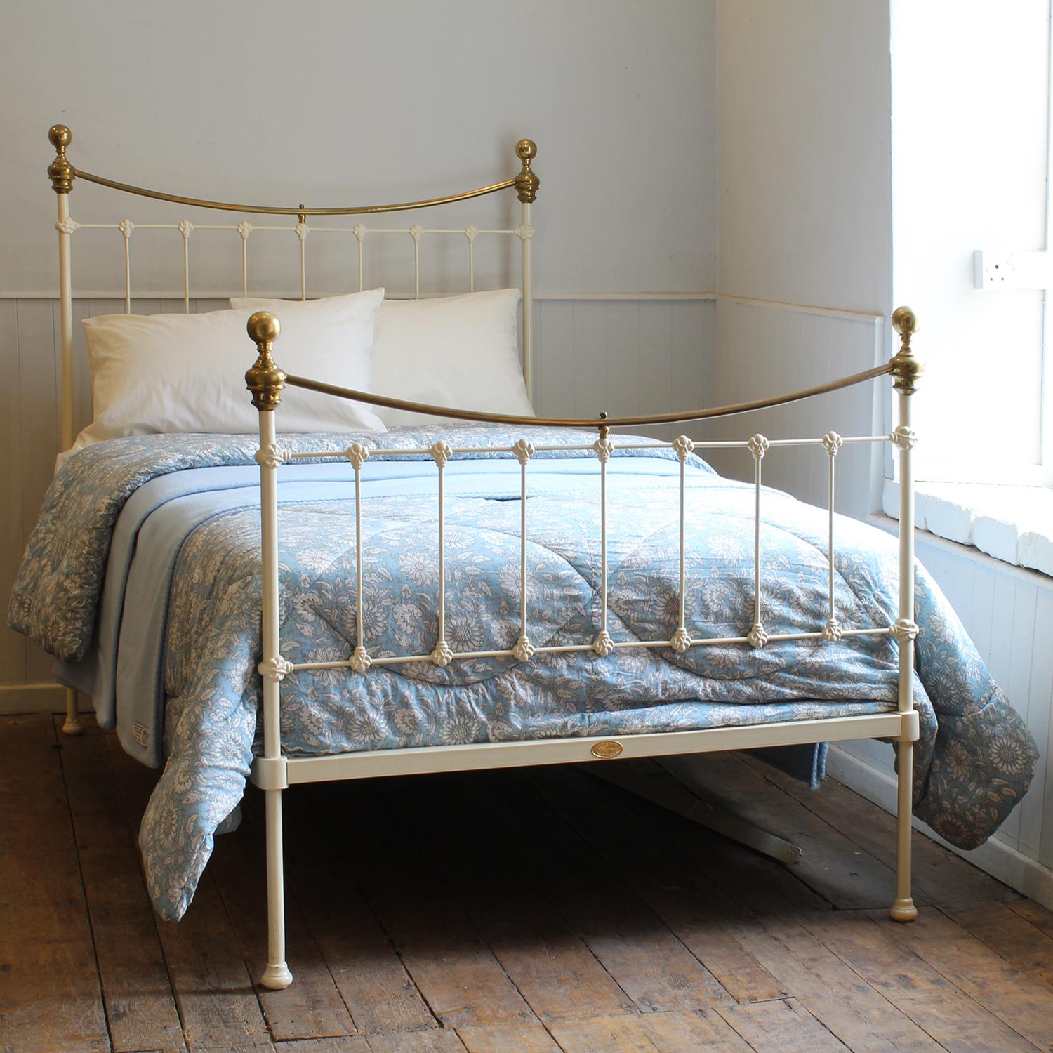 A small double Victorian cast iron and brass bedstead finished in cream with curved brass top rails, spherical knobs and simple castings.

This bed accepts a small double size 4ft wide (48 inch or 120cm) base and mattress. 

The price includes a