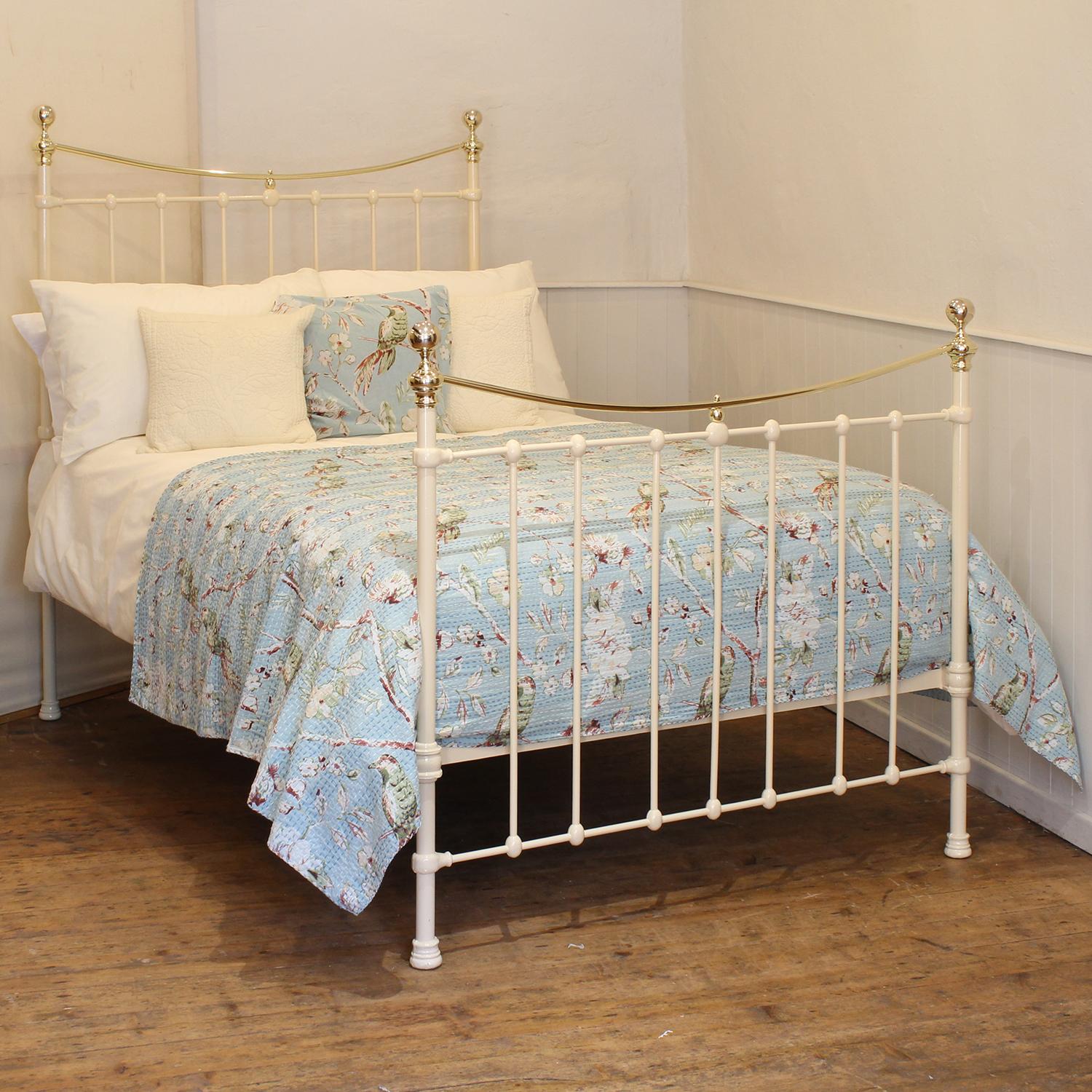 A small double Victorian cast iron and brass bedstead finished in cream with curved brass top rails and simple castings.

This bed accepts a small double size 4ft wide (48 inch or 120cm) base and mattress. 

The price includes a firm standard