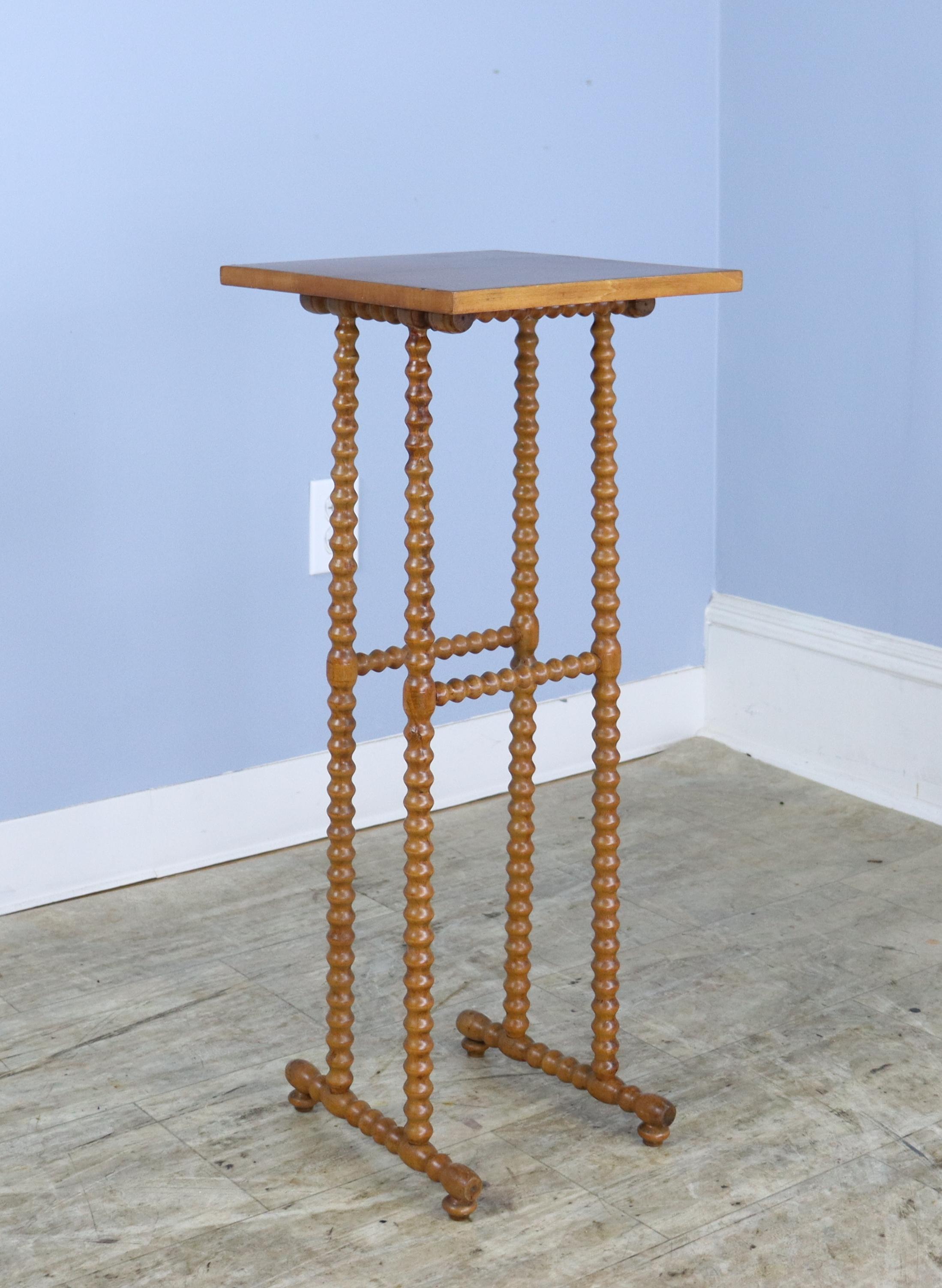 A small delicate side table with charming bobbin legs.  There is a small chip on the edge that has been filled, shown in last thumbnail.   Would pair nicely with our other bobbin legged side table, reference number 0623-MJ8A.