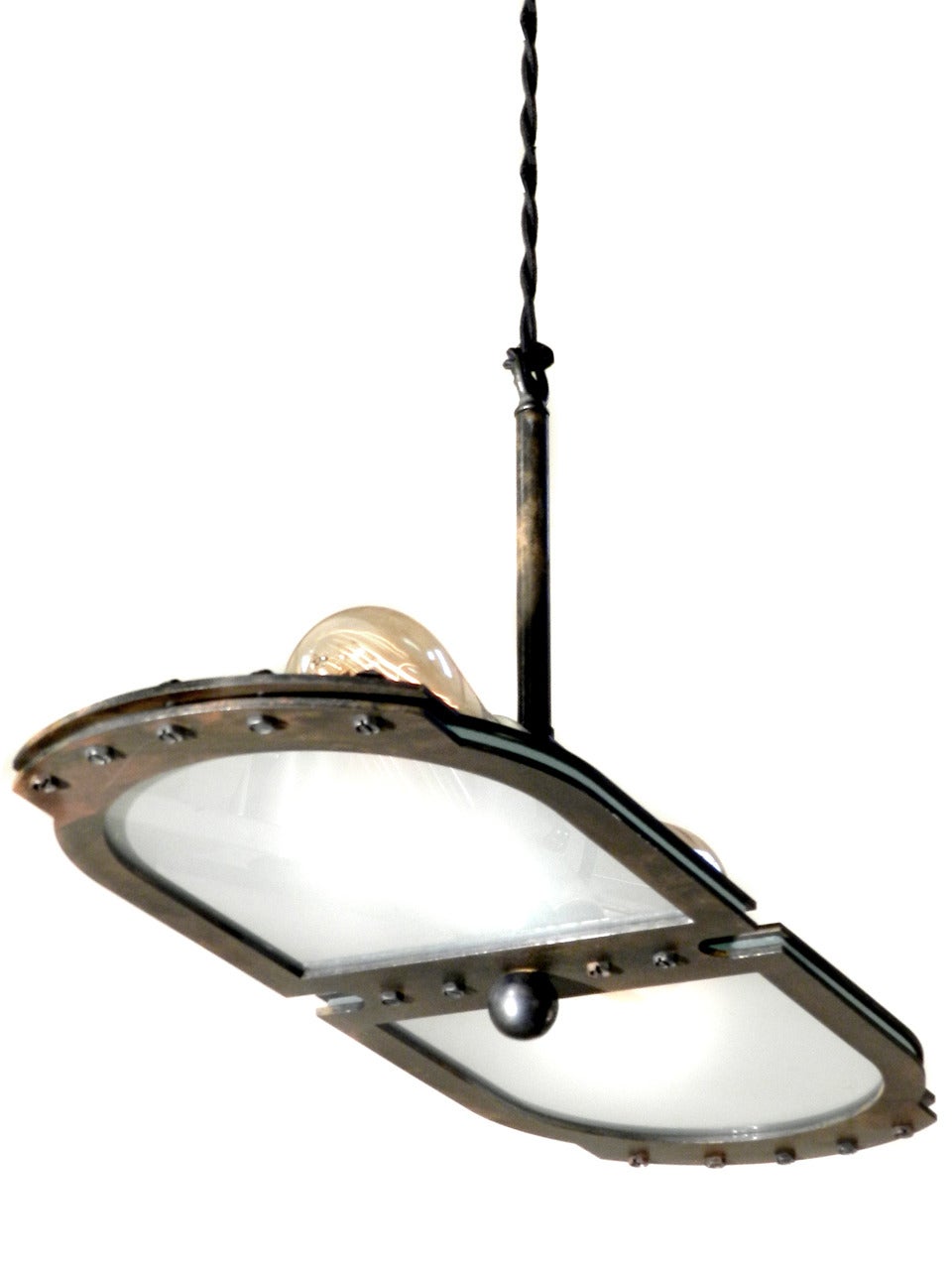 This small tracery style Industrial pendant fits comfortably with most styles. It's very architectural with clean lines… just look at the profile. The heavy steel frame has an aged patina and Industrial accents that are not over done. We designed