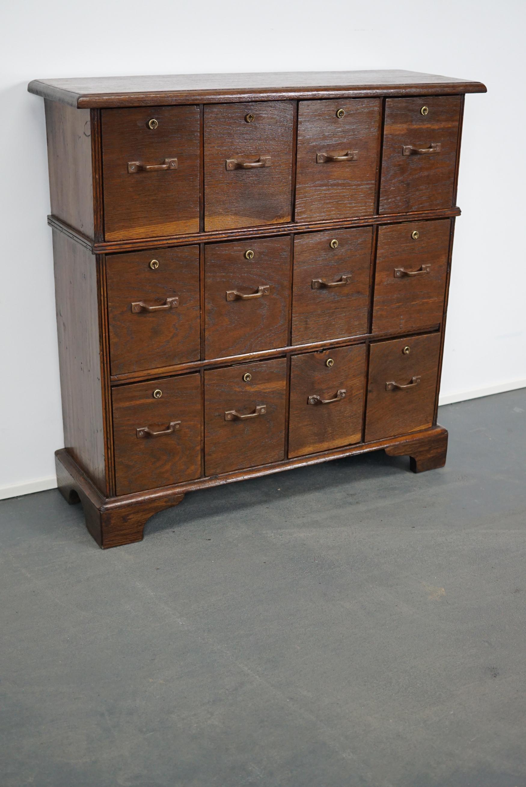 This apothecary / filing cabinet was produced during the 1930s in The Netherlands. This piece features 12 drawers. The interior dimensions of the drawers are: DWH 18.5 x 13.5 x 18.2 cm.