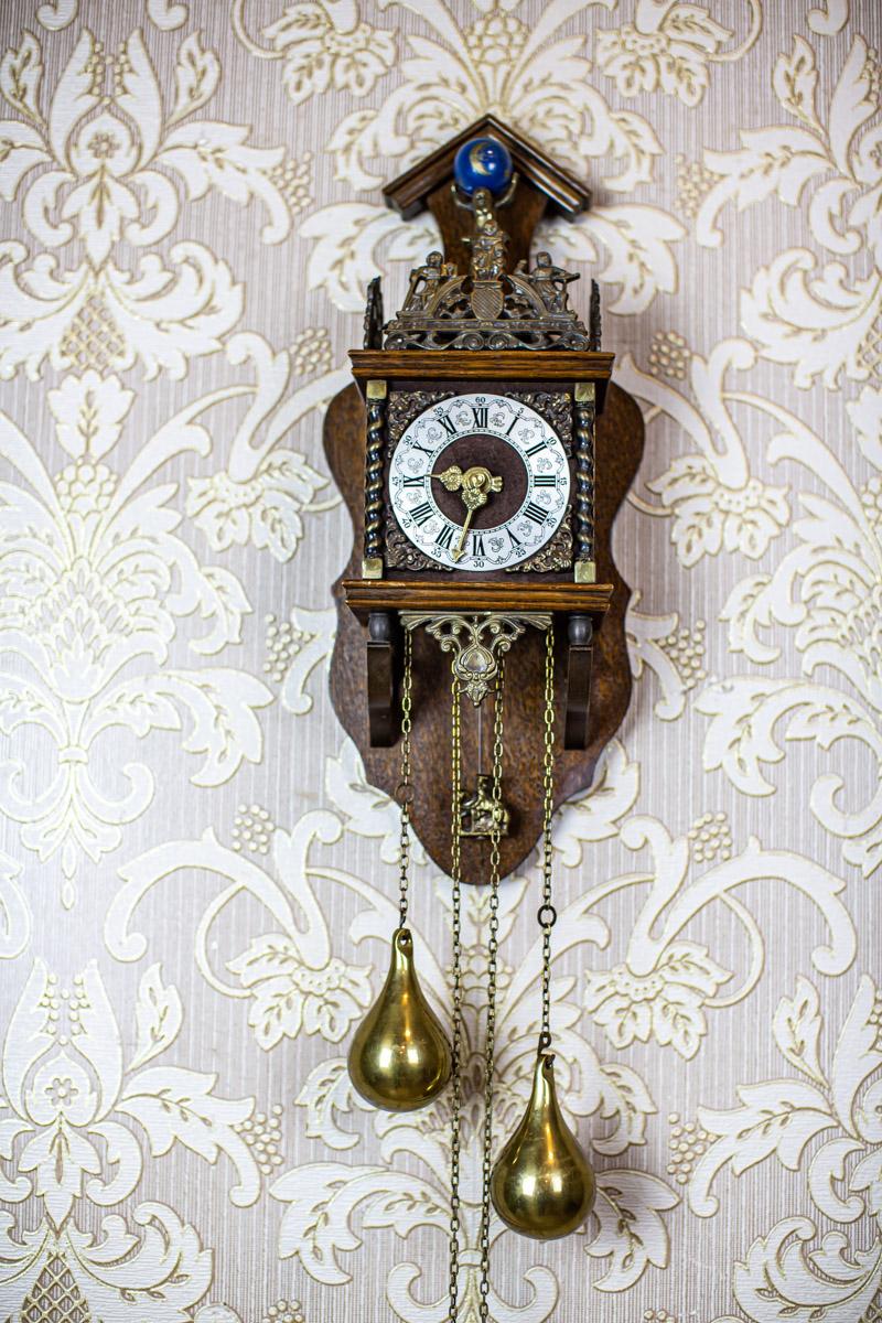 Small Dutch Wall Clock from Early 20th-Century Stylized as Staarta Clocks

We present you this small wall clock in an oak case with a weight power source. 
It was manufactured before 1939.
This piece of furniture resembles 19th-century Staarta