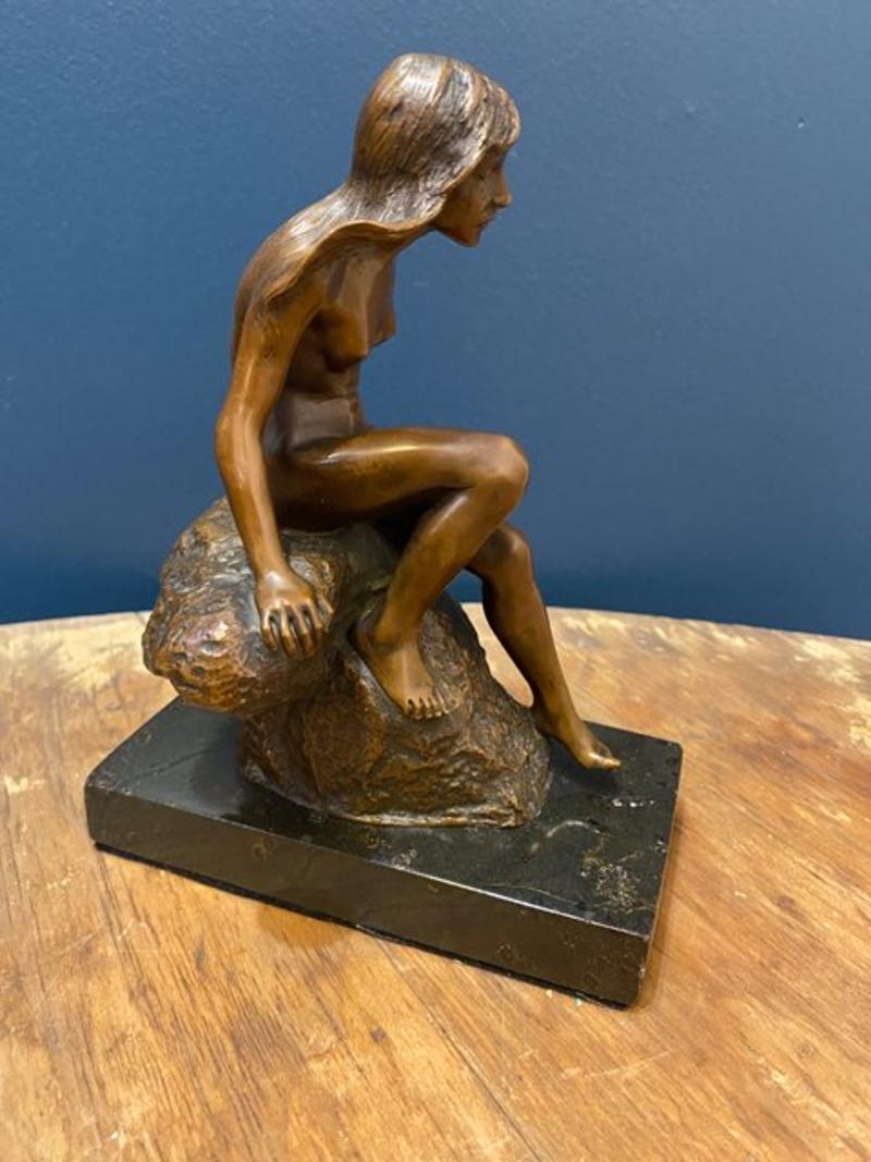 Small early 20th century bronze figurine of lady on rock mounted on marble slab. This sculpture of a nude maiden descending from a rock on a marble slab is absolutely. gorgeous. Unmarked, circa 1910-1920. 
Measures: 7