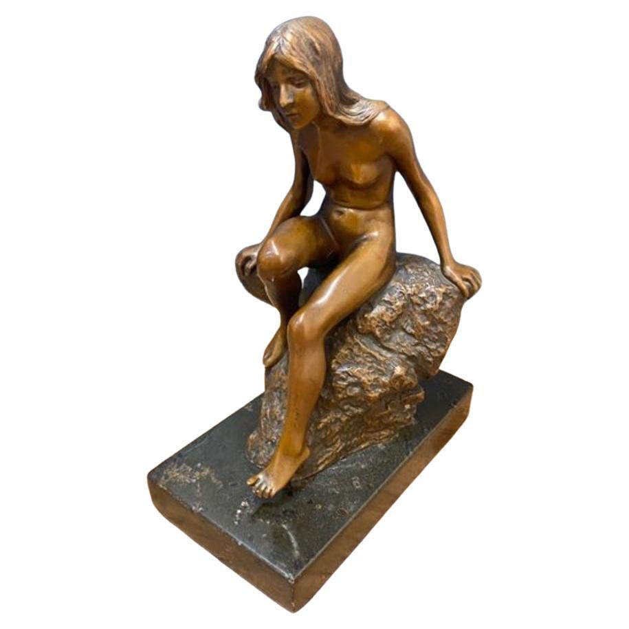 Petite figurine en bronze du début du 20e siècle représentant une femme sur un rocher monté sur un dalle de marbre