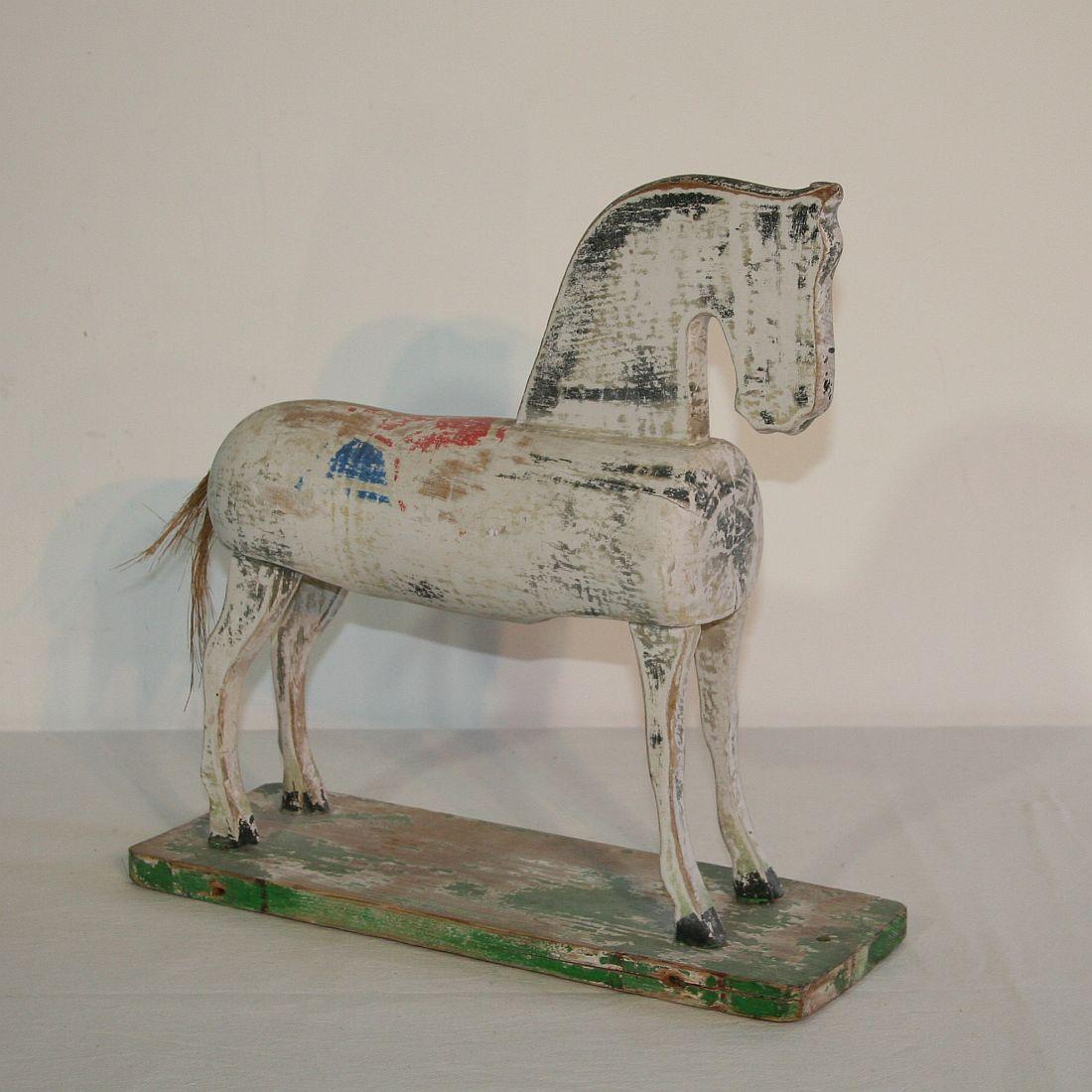 Nice small wooden horse with traces of its original color, France, circa 1920-1940. Weathered.









 