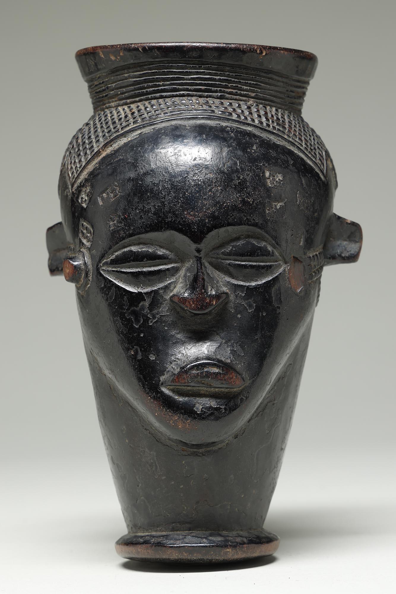 Small early Kuba Cup With Sweet Face, Fine Hair, Handle DRC, Africa
Finely carved hair in tight geometric form, small projecting ears.  Some damage and wear to lips, and keloid on proper left side of face missing.

It is in good condition with wear,
