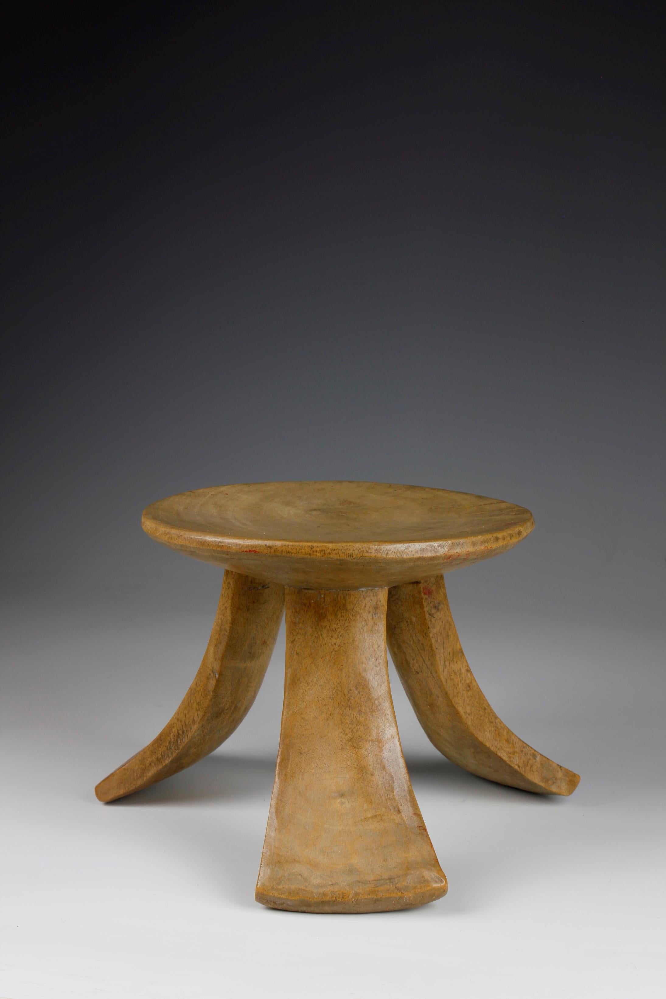The form of this early twentieth-century Pokot stool from Kenya exhibits a beautiful sculptural quality, in which three curved, flared and flattened legs support the flat circular seat. 

Small, three-legged stools such as this were carried and used