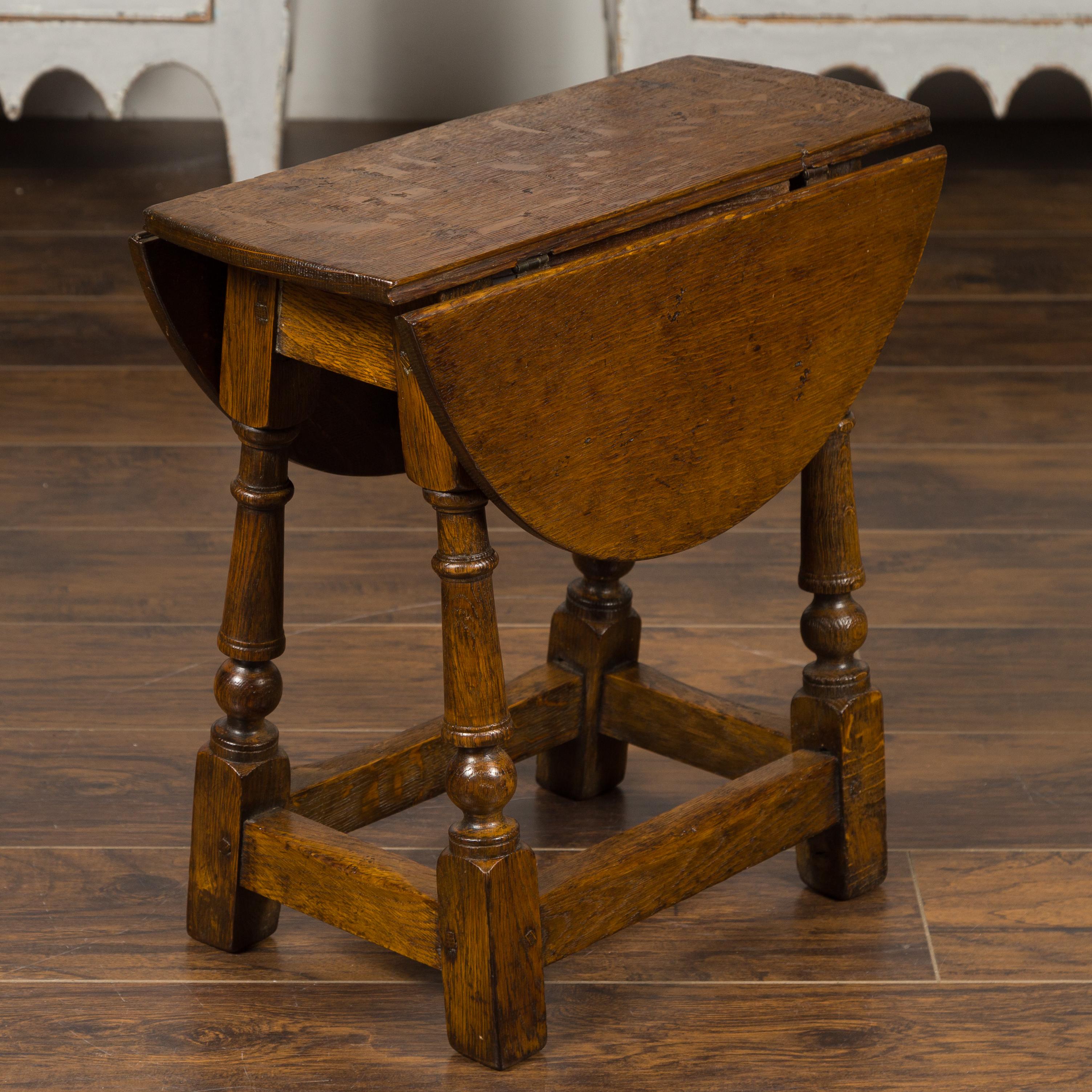 Kleiner englischer Eichenholztisch aus dem späten 19. Jahrhundert mit gedrechselten Beinen und seitlichen Streckern. Dieser Beistelltisch aus Eichenholz, der in den späten Jahren des 19. Jahrhunderts in England entstand, verfügt über zwei