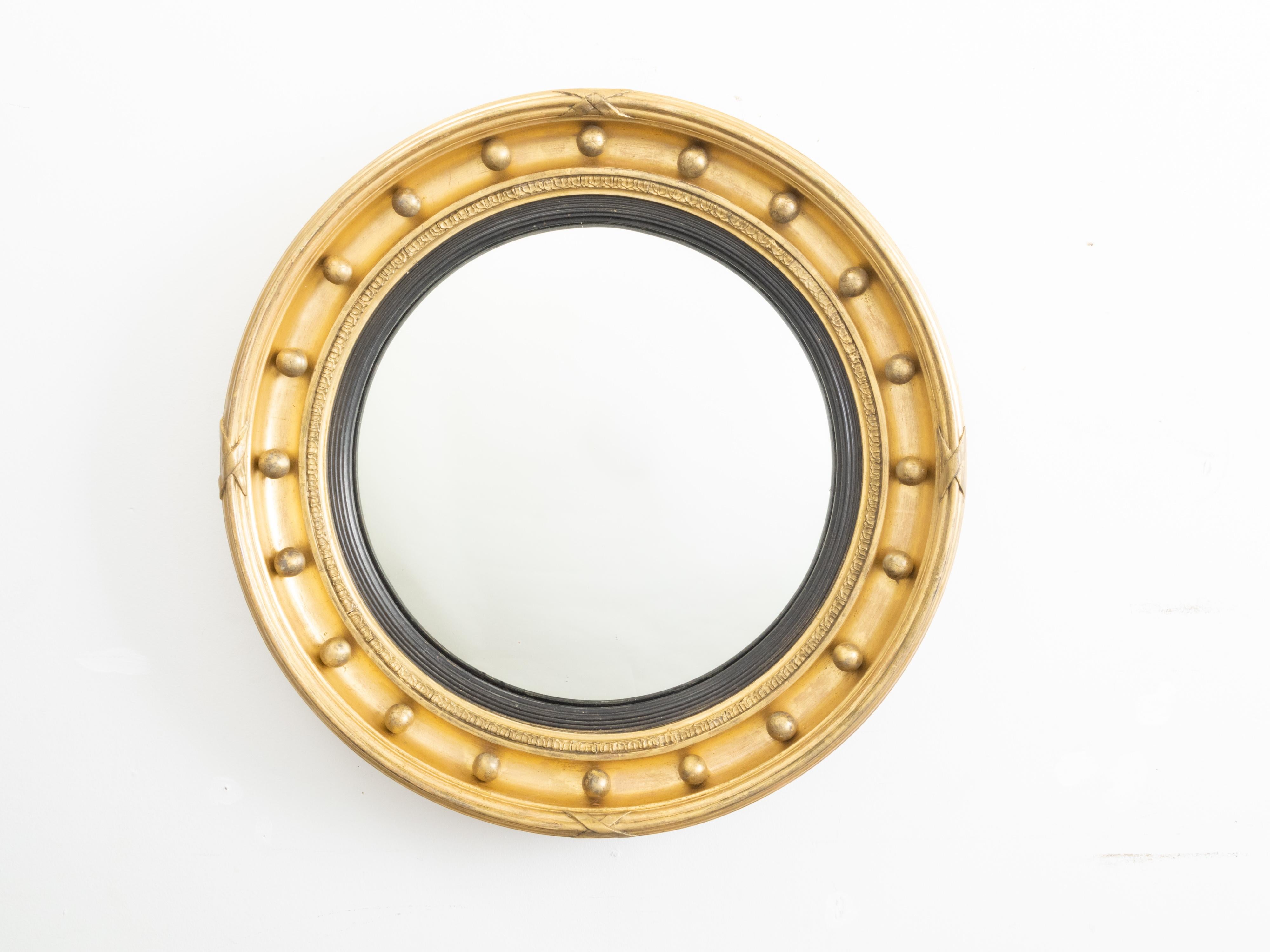 Ein kleiner englischer Girandole-Spiegel aus vergoldetem Holz aus dem 19. Jahrhundert mit ebonisierten, geriffelten Akzenten. Dieser stilvolle runde Spiegel, der im 19. Jahrhundert in England hergestellt wurde, hat eine zentrale Spiegelplatte, die