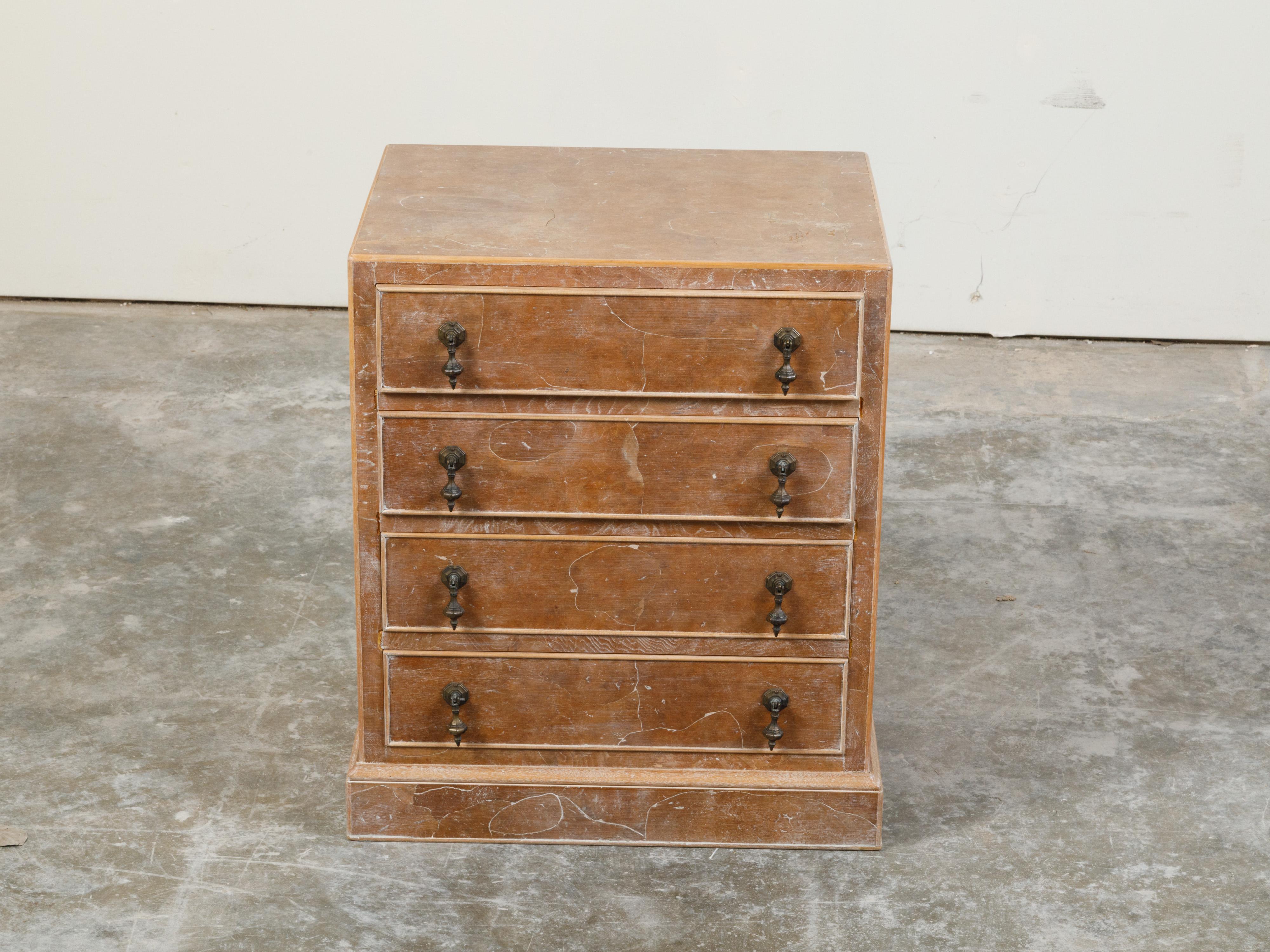 A small English burl wood chest with four drawers and distressed finish. Create in England, this small chest features a rectangular top sitting above four drawers each fitted with two ornate pulls. Boasting a nicely weathered appearance and resting