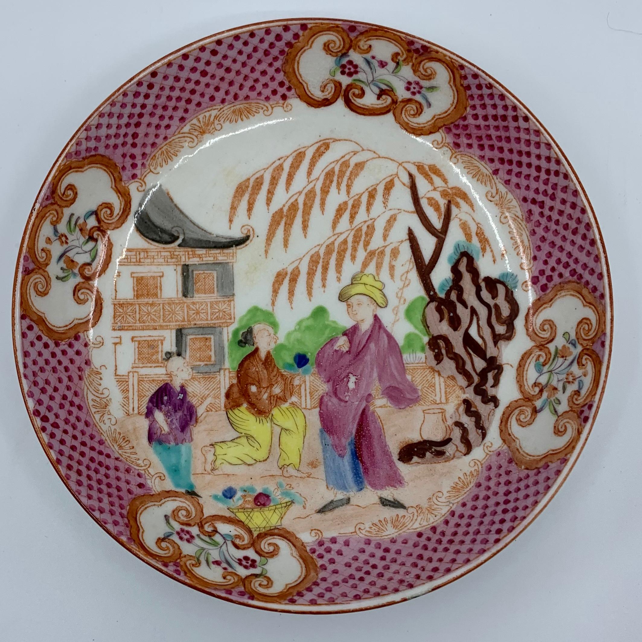 Small English chinoiserie plate. Staffordshire saucer with pink and puce border with four orange bordered windows centering three figures, from the pattern called 