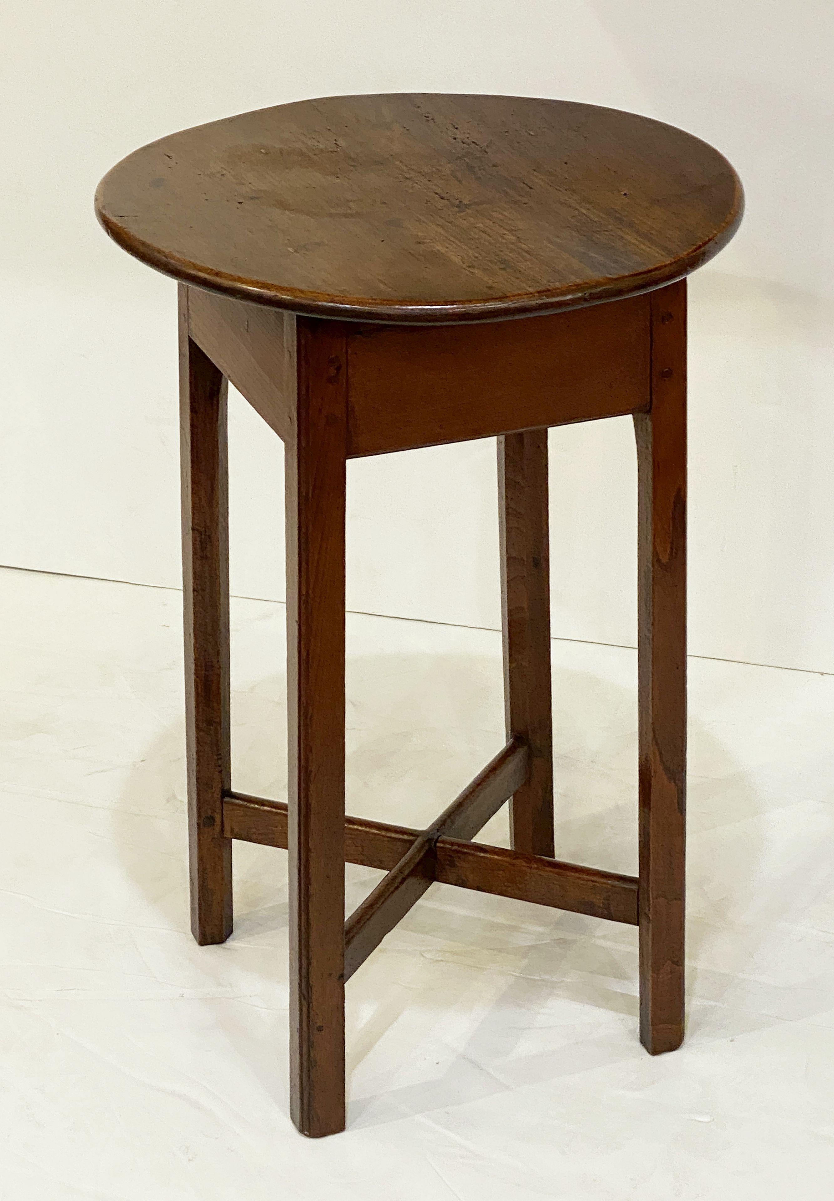 A fine small English cricket table of patinated oak featuring the traditional round or circular top over a four-sided shaped and pegged rustic frieze with hand-planed four-legged base and cross-brace stretcher.

Makes a nice occasional table or side