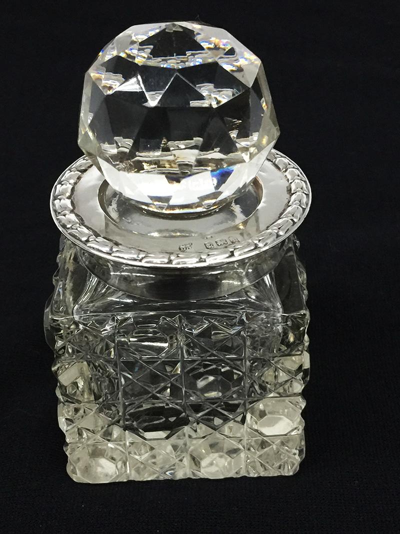Small English Crystal and Silver Scent Bottle by Boots Pure Drug Company, 1908

English Crystal cut and silver scent bottle with crystal stopper, made by Boots Pure Drug Company and dated 1908.  The scent bottle silver neck has the silver hall mark
