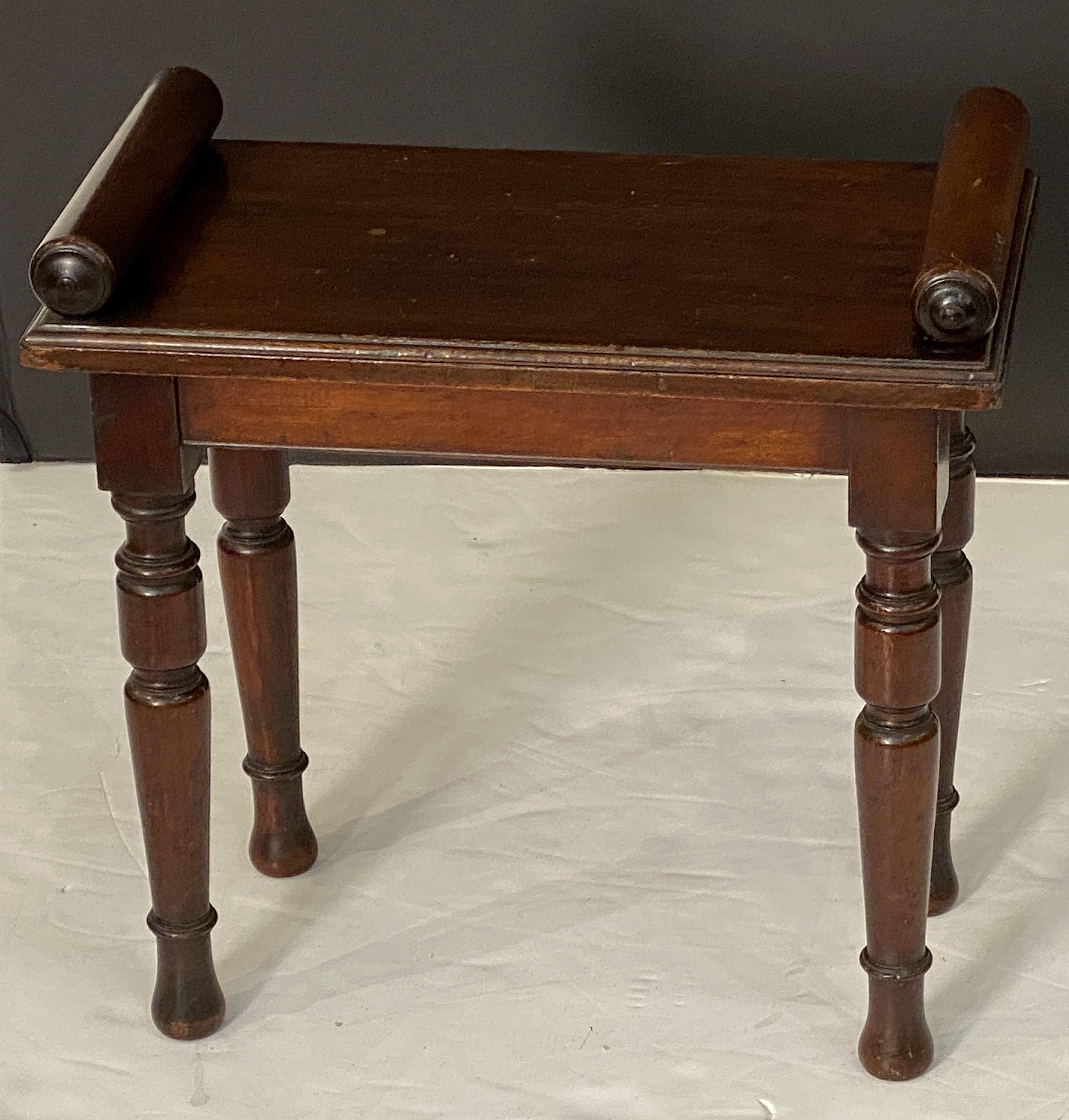 A fine English hall bench or window seat (stool) of mahogany from the Edwardian era, featuring turned handles at opposing ends over a long plank seat and set upon four turned legs.

Dimensions:

H 19 5/8 inches
W 20 inches
D 11 inches

Seat