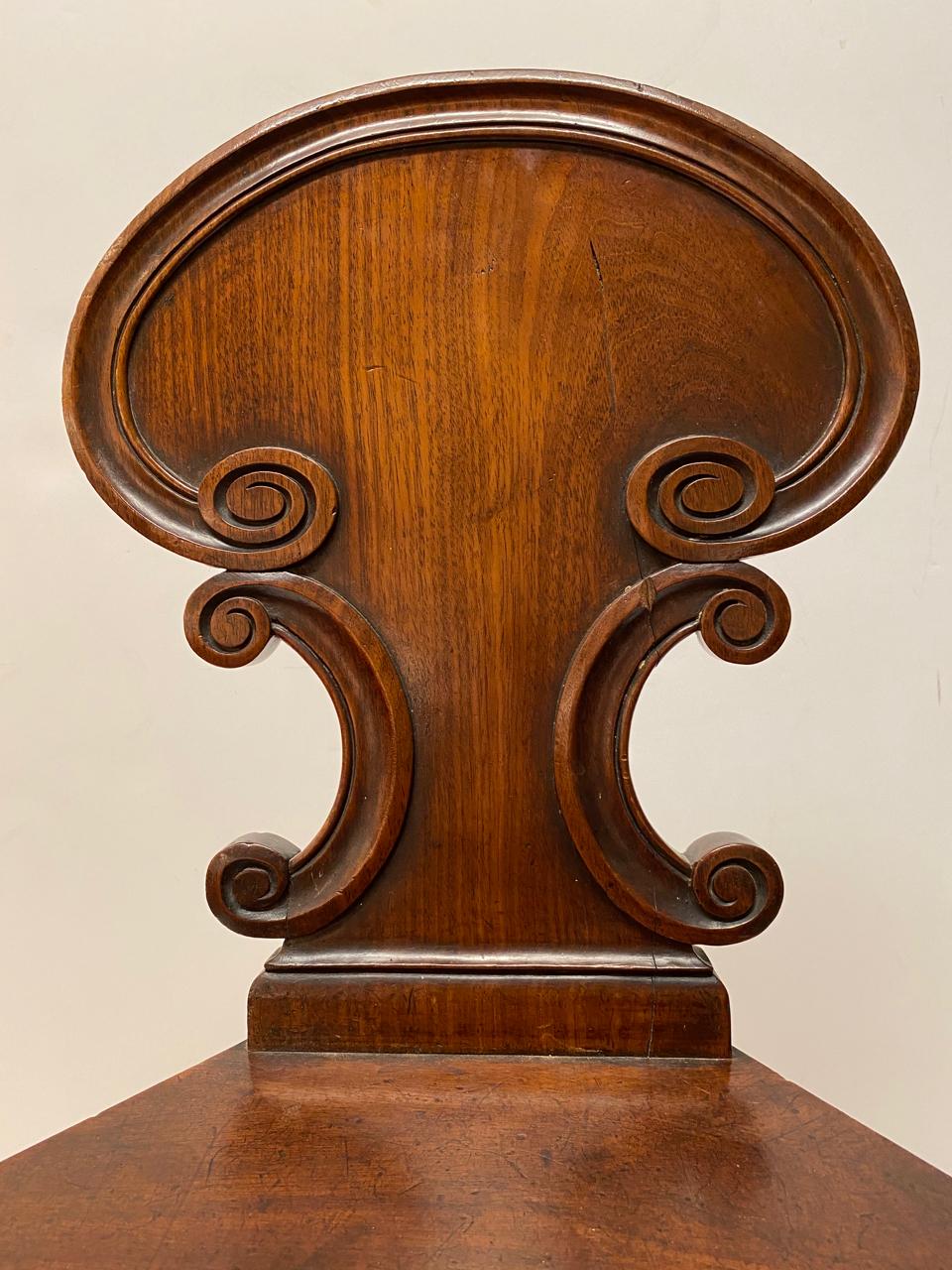 This is a small beautifully crafted English solid mahogany hall chair. The chair dates to the late 19th century and is in overall very good condition.