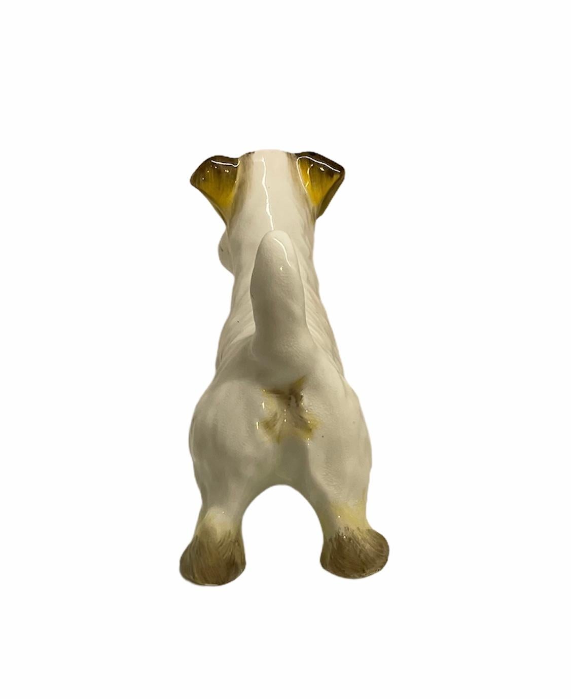 This is an adorable English porcelain small figurine of a Scottish dog. It is hand painted white and highlighted with yellow-brownish spots. Very well made. It is stamped made in England in one of its paws.