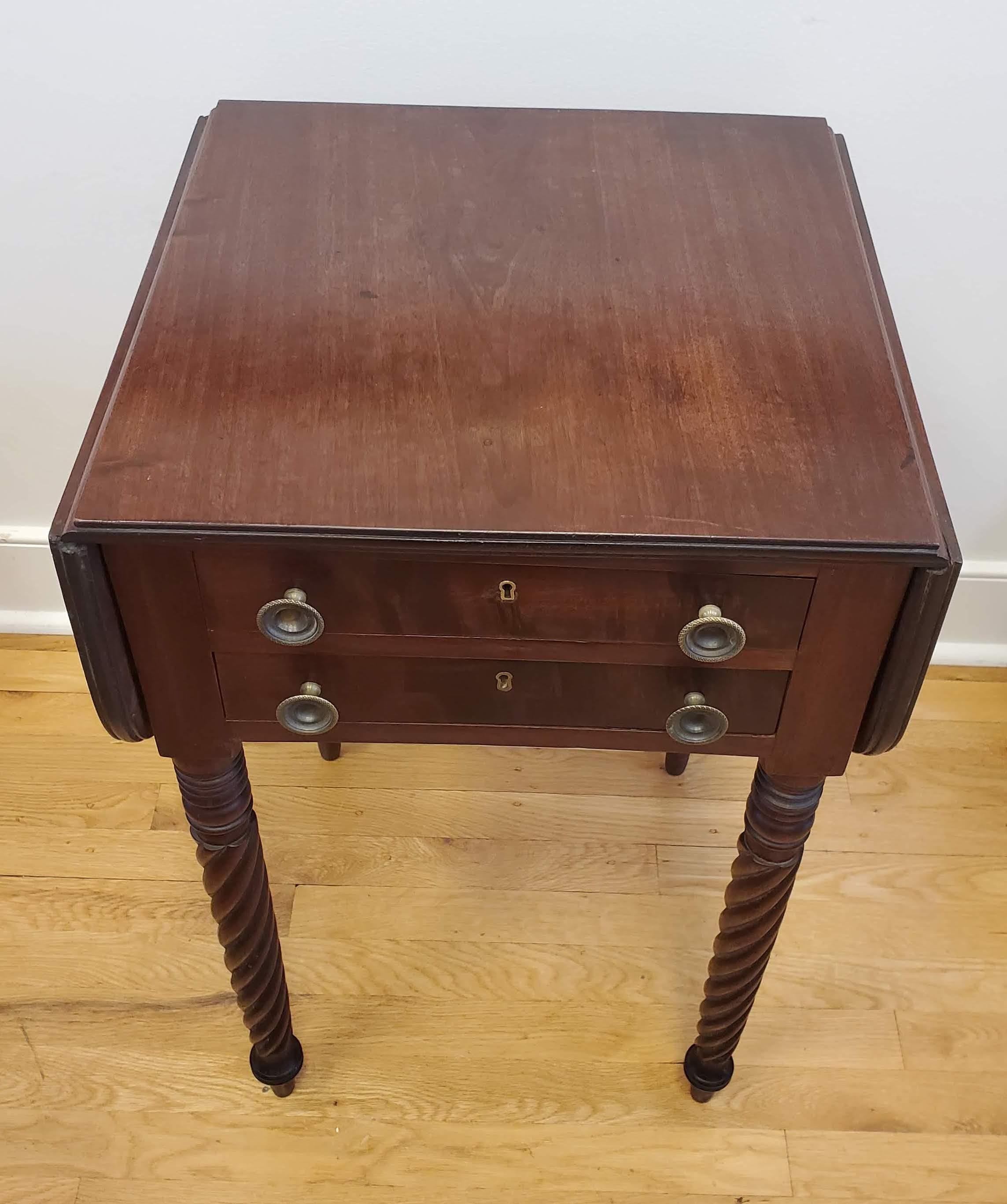 Small English Regency drop leaf side table. Spiral turned legs with two drawers. Made of Honduras Mahogany. Great proportions. England, circa 1825. 
Measures: 29” H 18” W 17” D.