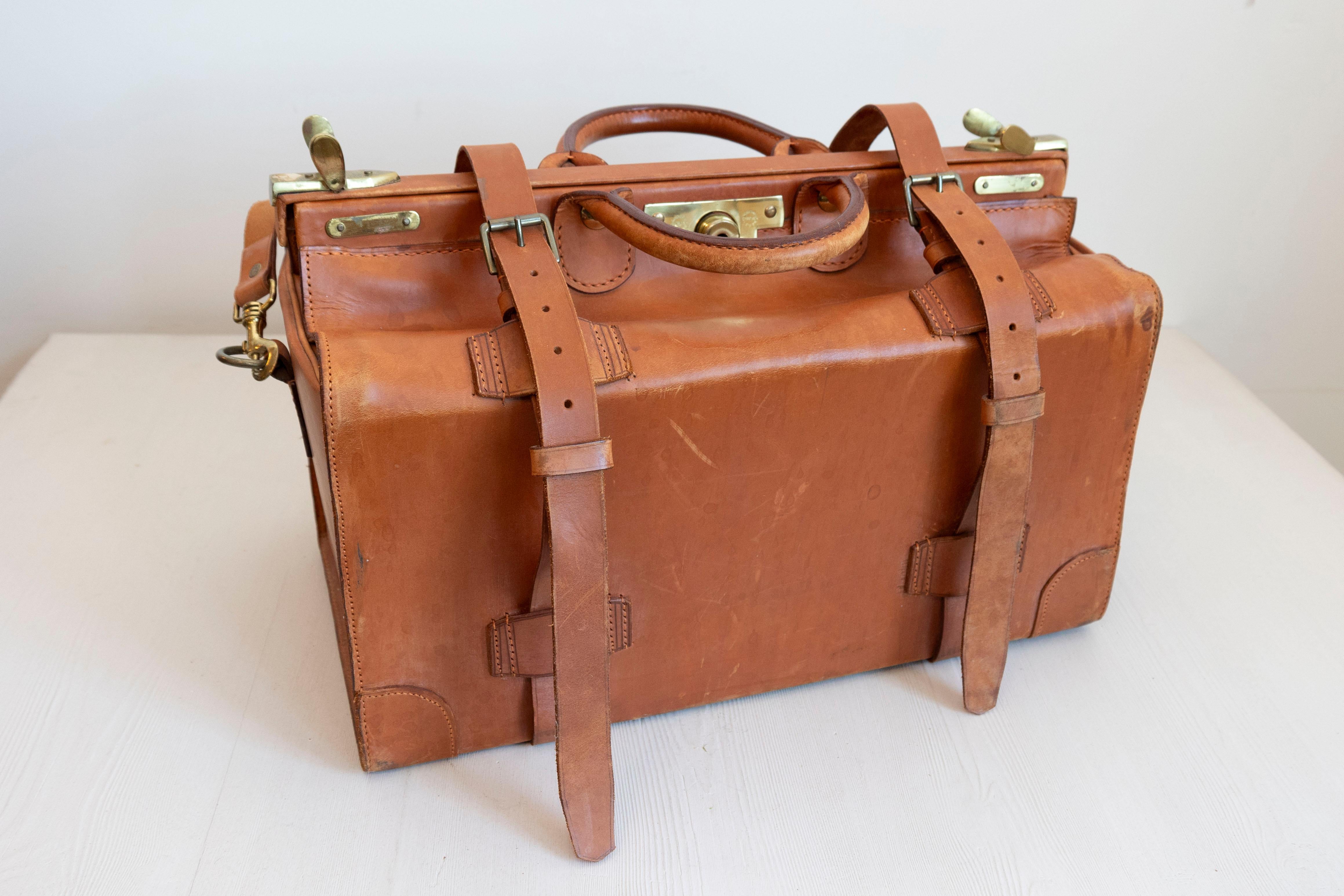 An English vintage small leather case from the mid 20th century, with brass accents. Created in England during the 20th century, this small leather case is made of brown leather accented with brass hardware. Showcasing a top handle, the case, made