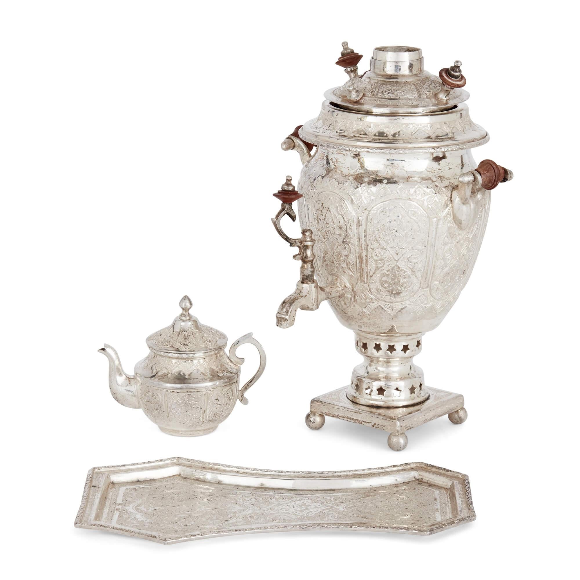 Small engraved silver part-tea service of Persian design
Persian, 20th Century
Samovar: Height 23cm, width 16cm, depth 15cm
Teapot: Height 9cm, width 10cm, depth 6.5cm

Decorated with elaborate Persian designs, this excellent tea service comprises a