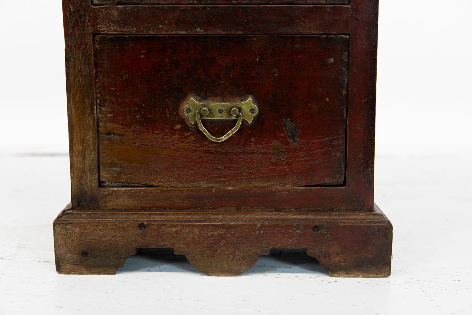 Small European glass door cupboard has paneled sides and its original feet and shaped apron. The top has a carved crest rail.