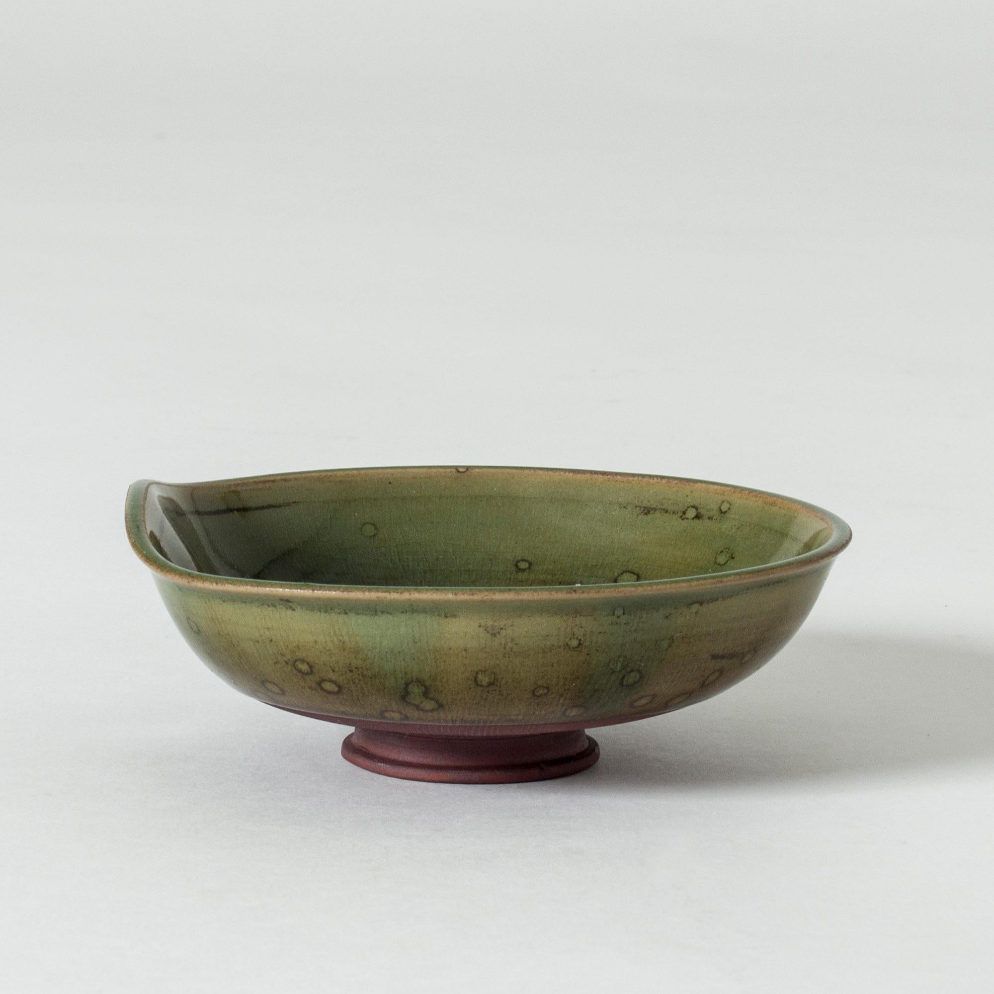 Beautiful, small “Farsta” bowl by Wilhelm Kåge, with an earthy green glaze. The shape is reminiscent of a water lilly leaf.

“Farsta” stoneware is recognized as being the best and most exclusive that has come out of Swedish Arts & Crafts. The