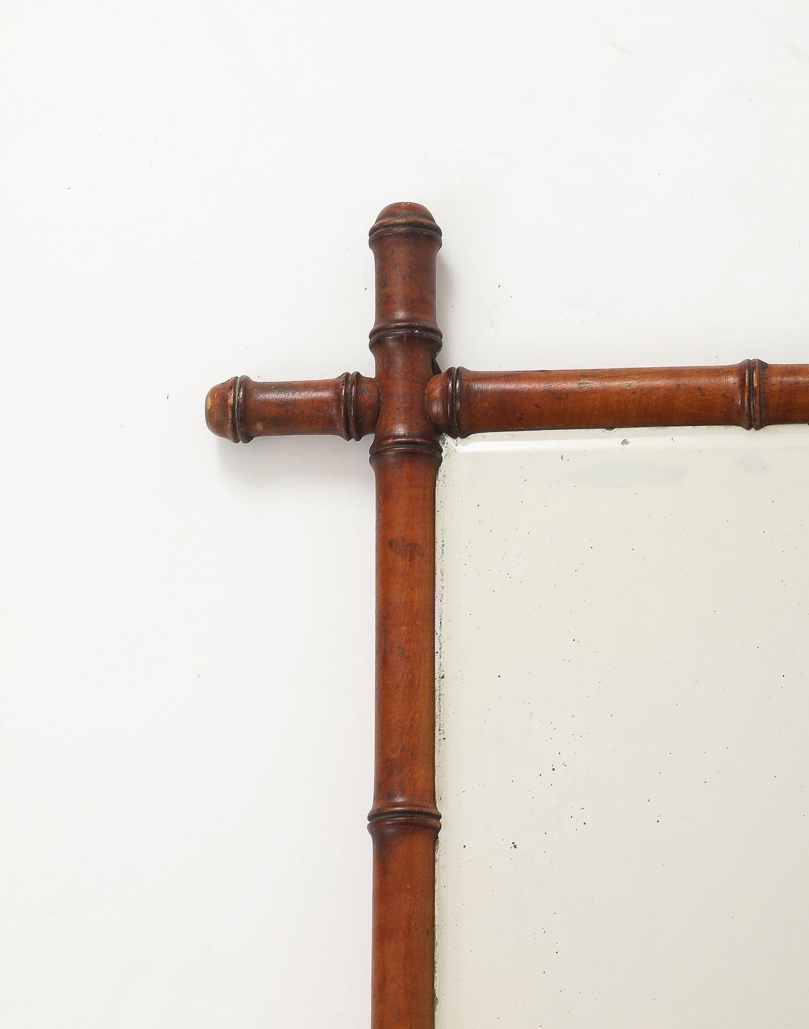 Este encantador espejo inglés de los años 40 presenta un marco de bambú de imitación finamente tallado con una rica y cálida pátina que imita maravillosamente el aspecto natural del bambú. El espejo conserva su placa de cristal original, que muestra