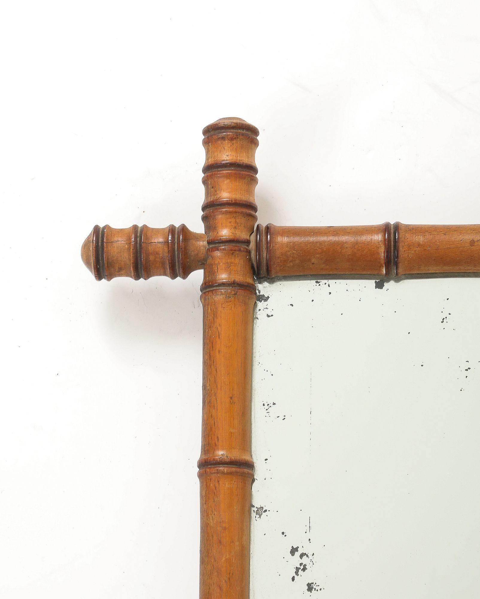 Ce charmant miroir anglais des années 1940 présente un cadre en faux bambou finement sculpté avec une patine riche et chaude qui imite magnifiquement l'aspect naturel du bambou. Le miroir a conservé sa plaque de verre d'origine, qui a légèrement