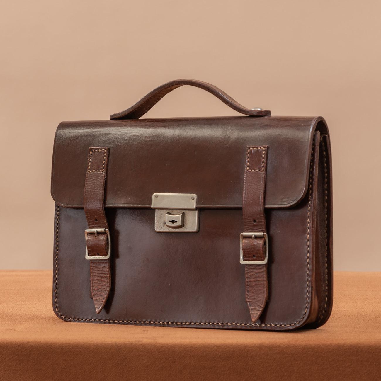 A handsome English made, dark brown leather one pocket flap over briefcase with two buckled straps and central nickel plated catch. Circa 1950.

Dimensions: 31 cm/12? inches (length) x 22.5 cm/8? inches (height) x 6 cm/2? inches (thick).

Bentleys