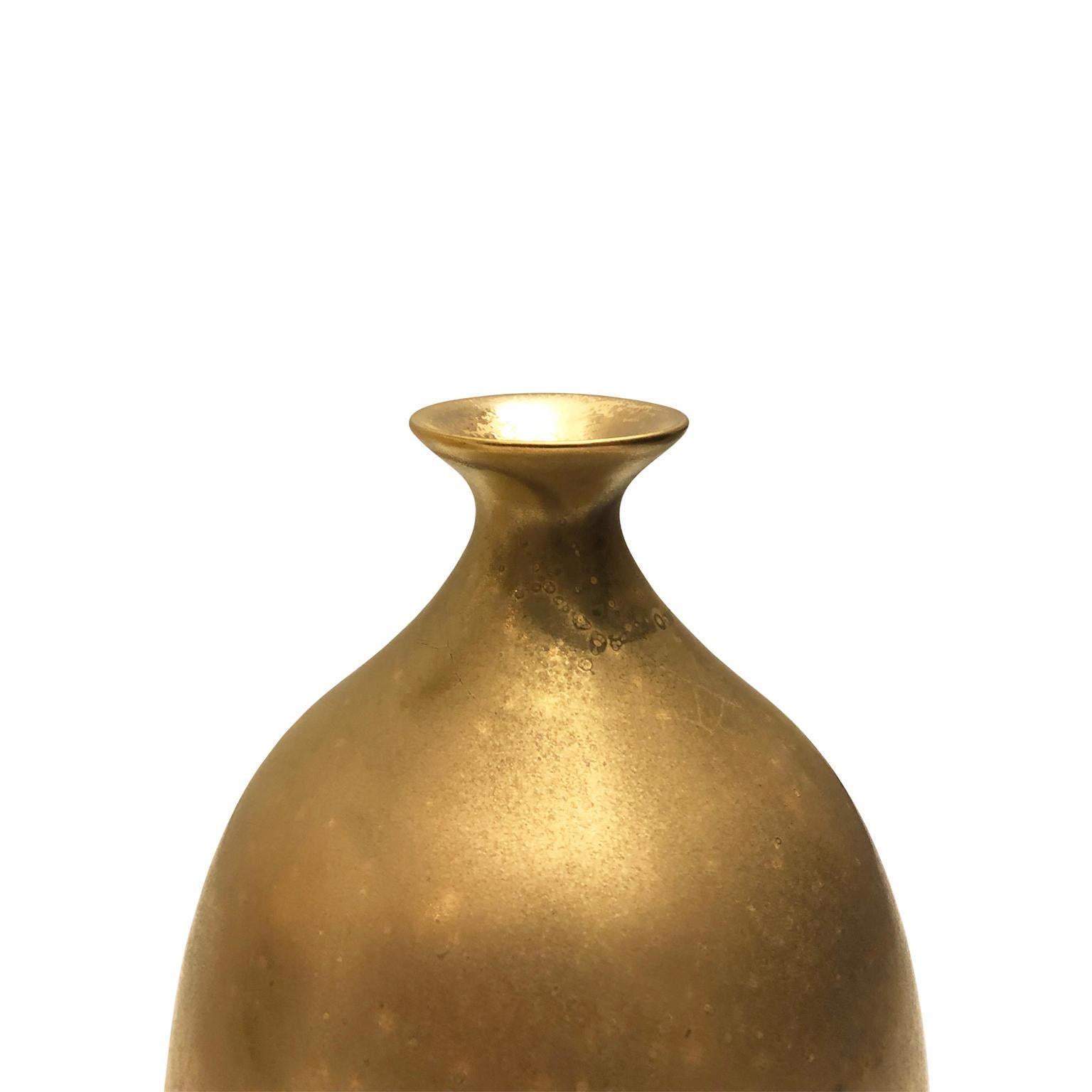 Small ceramic bottle vase with flared bottom and burnished gold lustre glaze by Sandi Fellman, 2019. 

Veteran photographer Sandi Fellman's ceramic vessels are an exploration of a new medium. The forms, palettes, and sensuality of her photos can