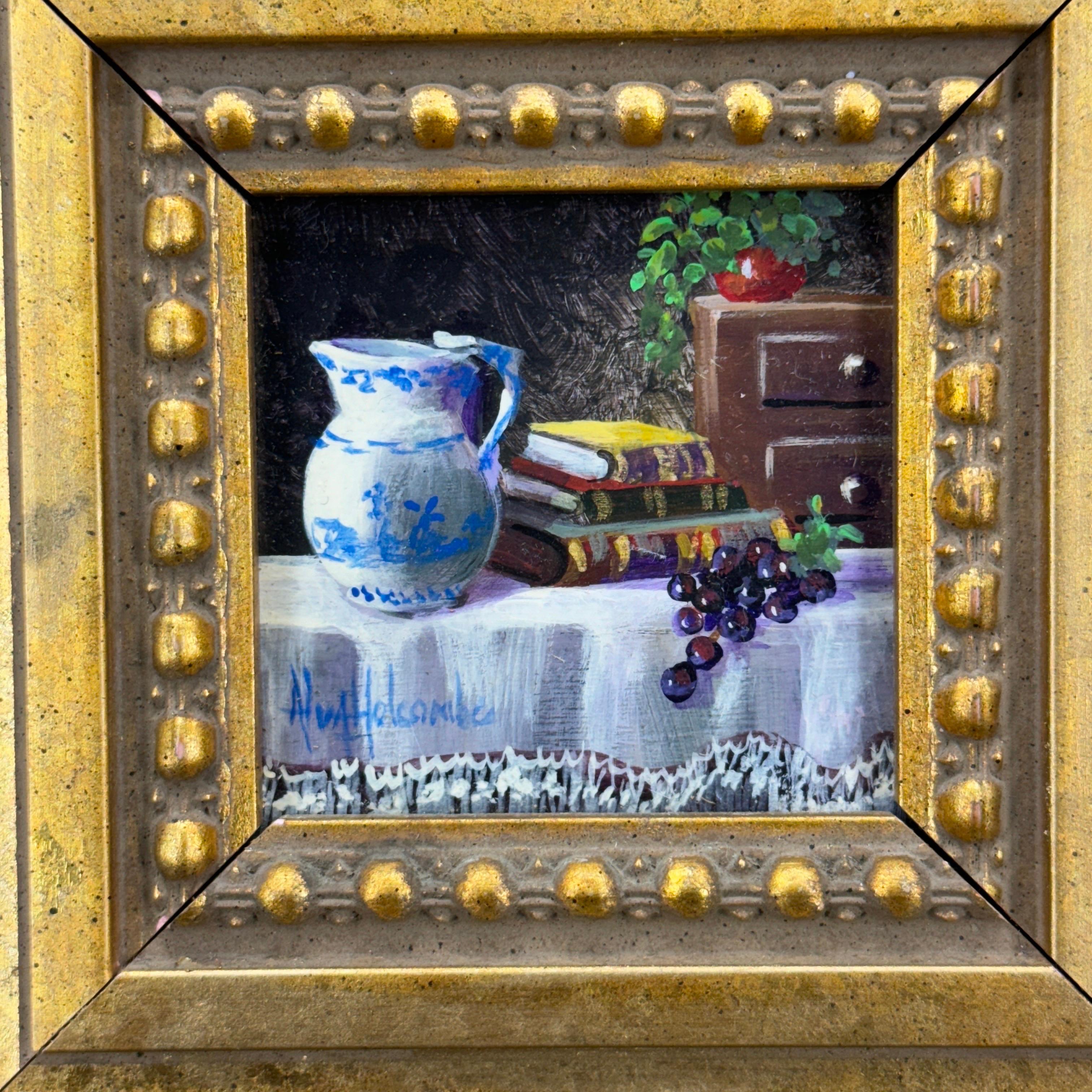 Esta pintura al óleo en miniatura, titulada Jarra de Delft, está firmada por el artista Alva Holcombe. La escena incluye la jarra de Delft azul y blanca, libros y fruta, todo ello sobre un mantel decorativo blanco. Maravillosa obra de arte que puede