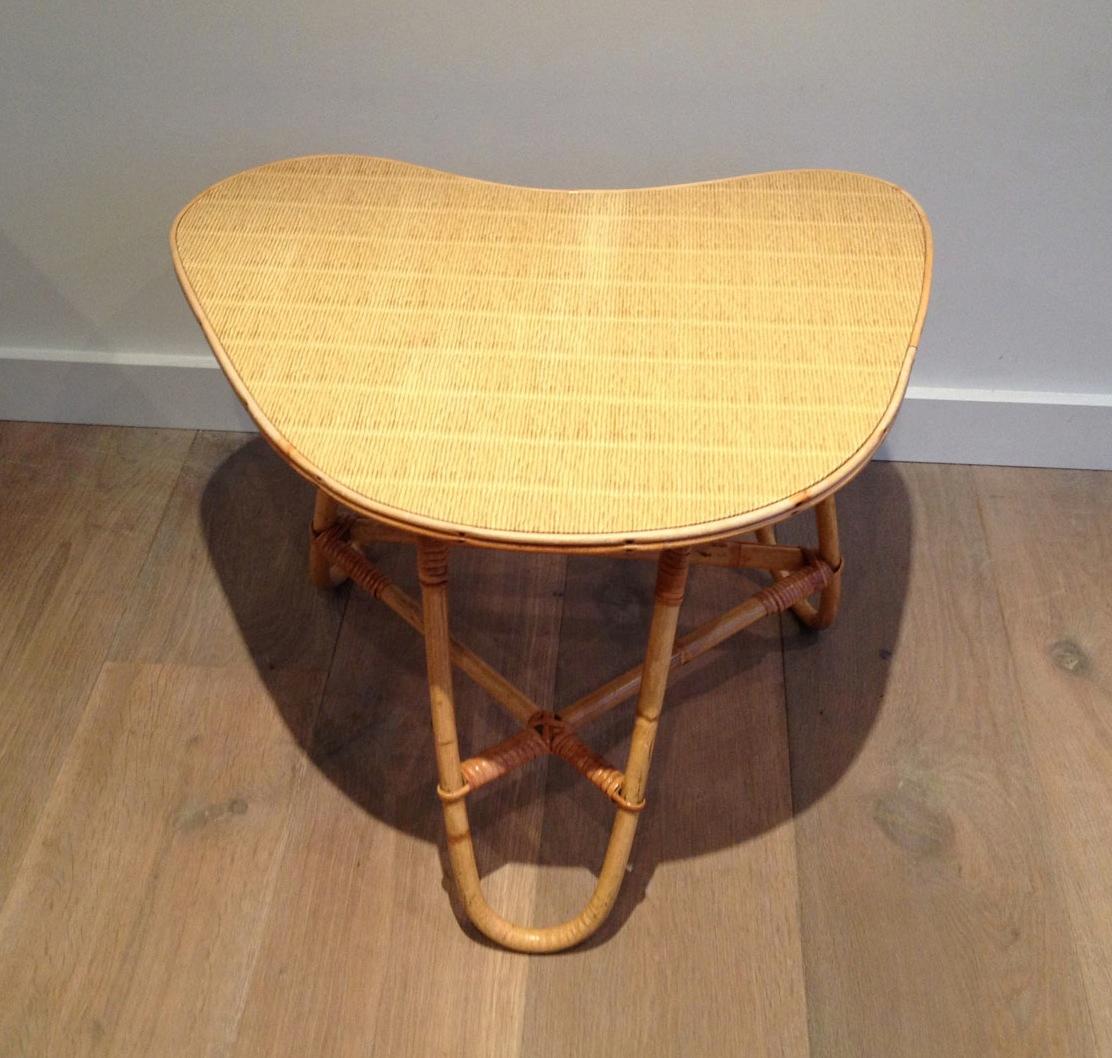 Cette petite table basse de forme libre est fabriquée en rotin. Il s'agit d'une œuvre française attribuée aux célèbres designers Adrien Audoux et Frida Minet. Circa 1970.