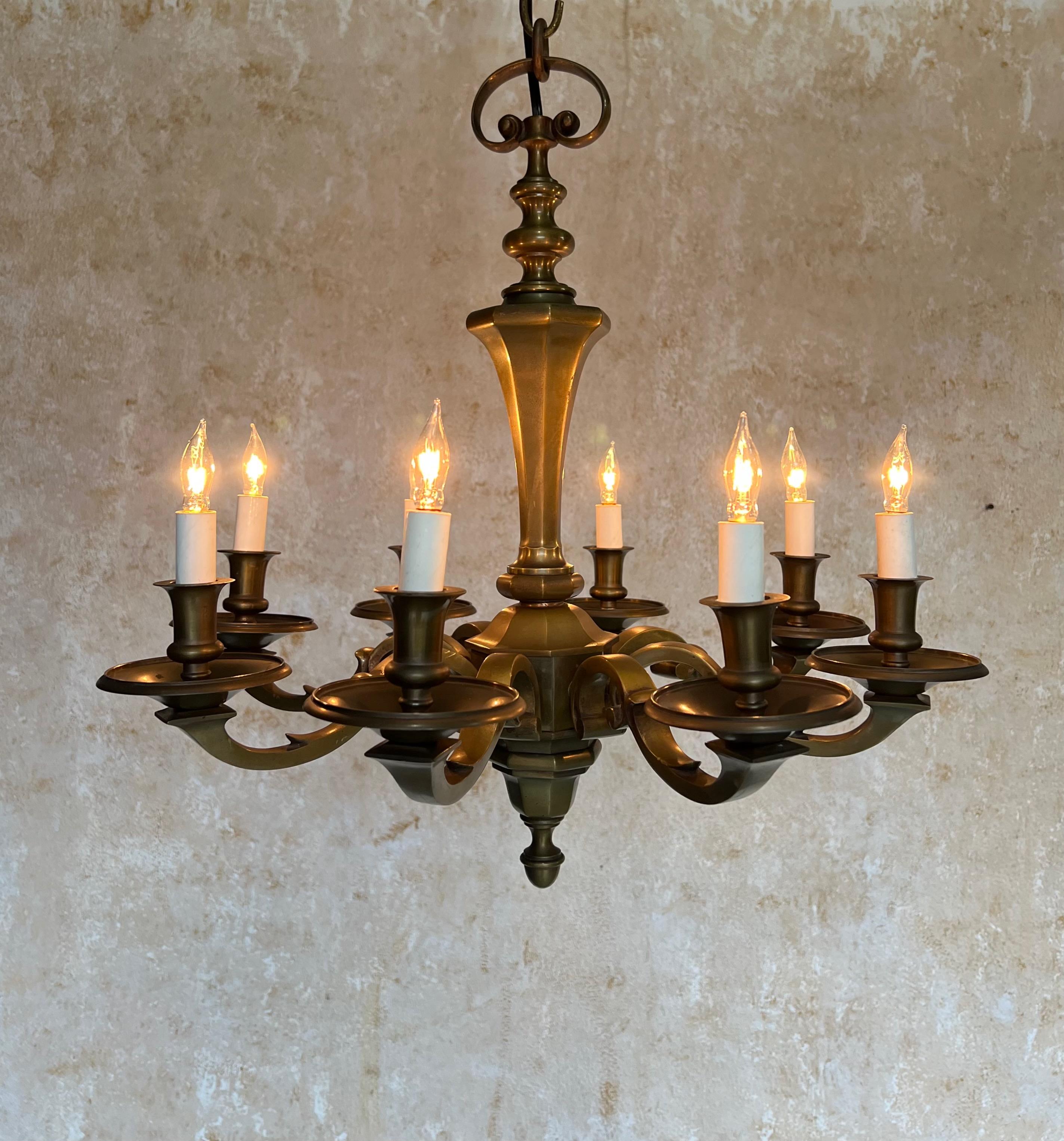 Elevate your space with this lovely French 1940s bronze chandelier, featuring eight ornate arms and a beautifully aged, patinated finish. This stunning piece measures 22 inches in height with a diameter of 21 inches, making its petite size perfect