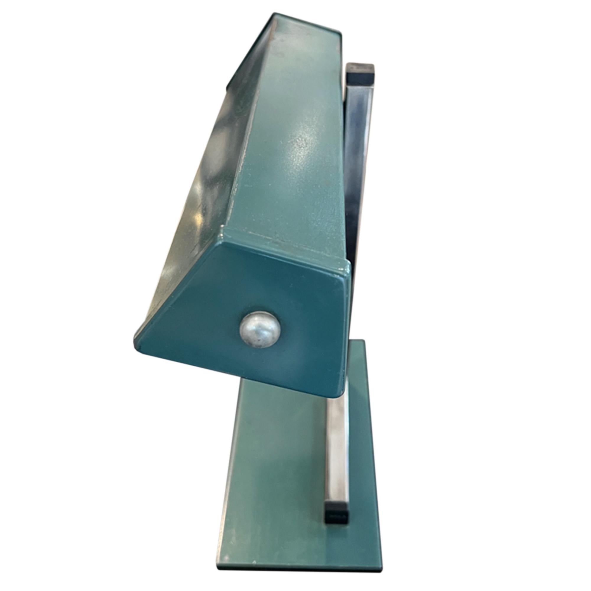 Esta es una estupenda lámpara de banquero de mediados de siglo, fabricada en Francia con acero.

La lámpara conserva la pintura verde original y el interruptor de encendido/apagado de baquelita en el lateral de la pantalla. 

Lo hemos recableado