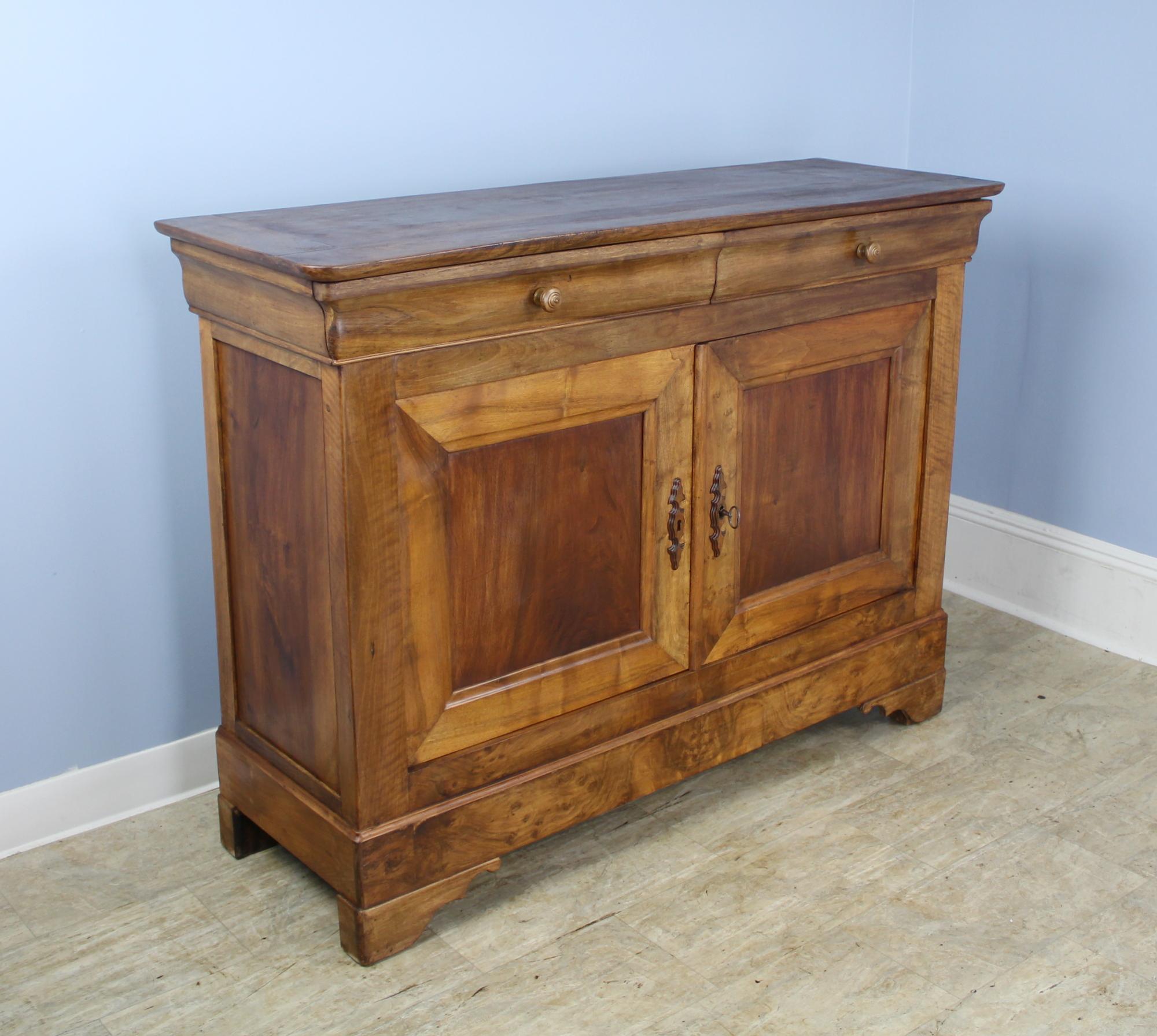 Stunning buffet, two doors and two drawers above, Classic Louis Philippe style. The walnut grain is as good as it gets and the dimensions of the console are excellent. Pretty top and stylized feet add a note of interest. We love the whimsical wooden