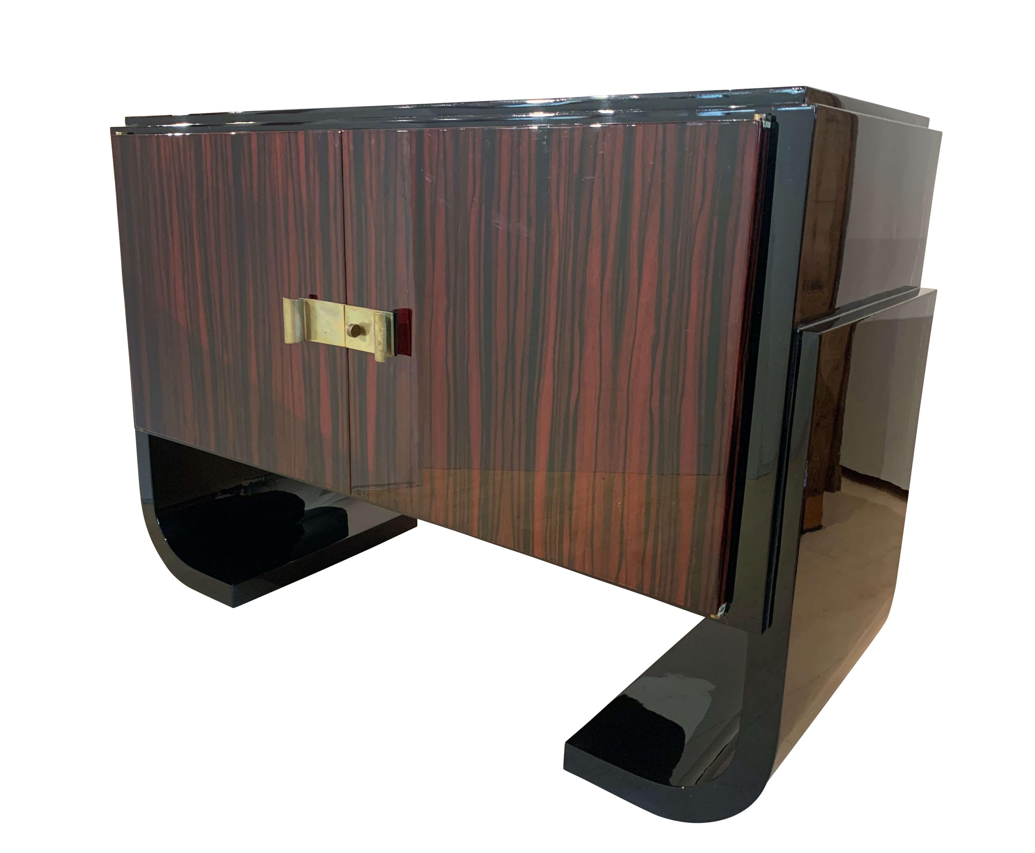 Small French Art Deco sideboard, macassar and black lacquer, 1930s

Provenience: France, 1930s
Macassar veneered and lacquered on the doors. Black piano lacquer on the legs, sides and top.
Doors inside and three drawers veneered in mahogany and