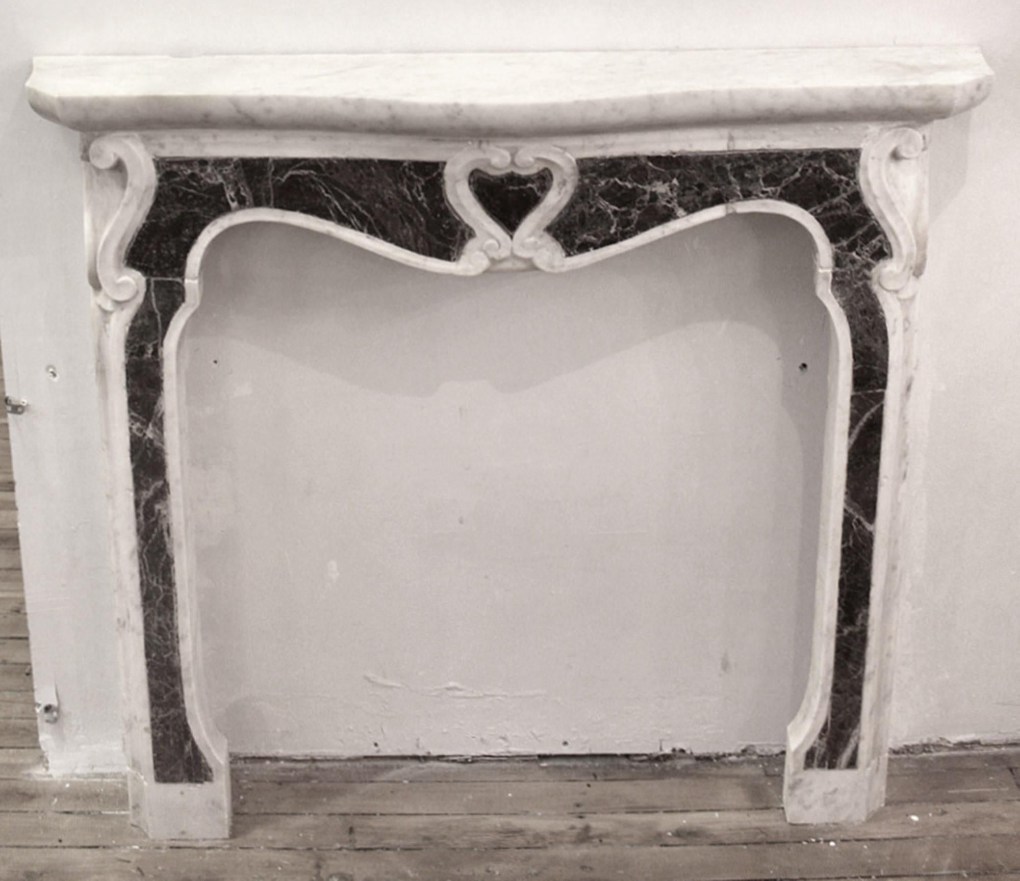 Exhibiting a remarkably distinctive Pompadour style, this marble fireplace mantel stands out with its exceptional features. The mantel showcases a harmonious blend of light gray Carrara marble and inlaid burgundy marble. Every facet of this design