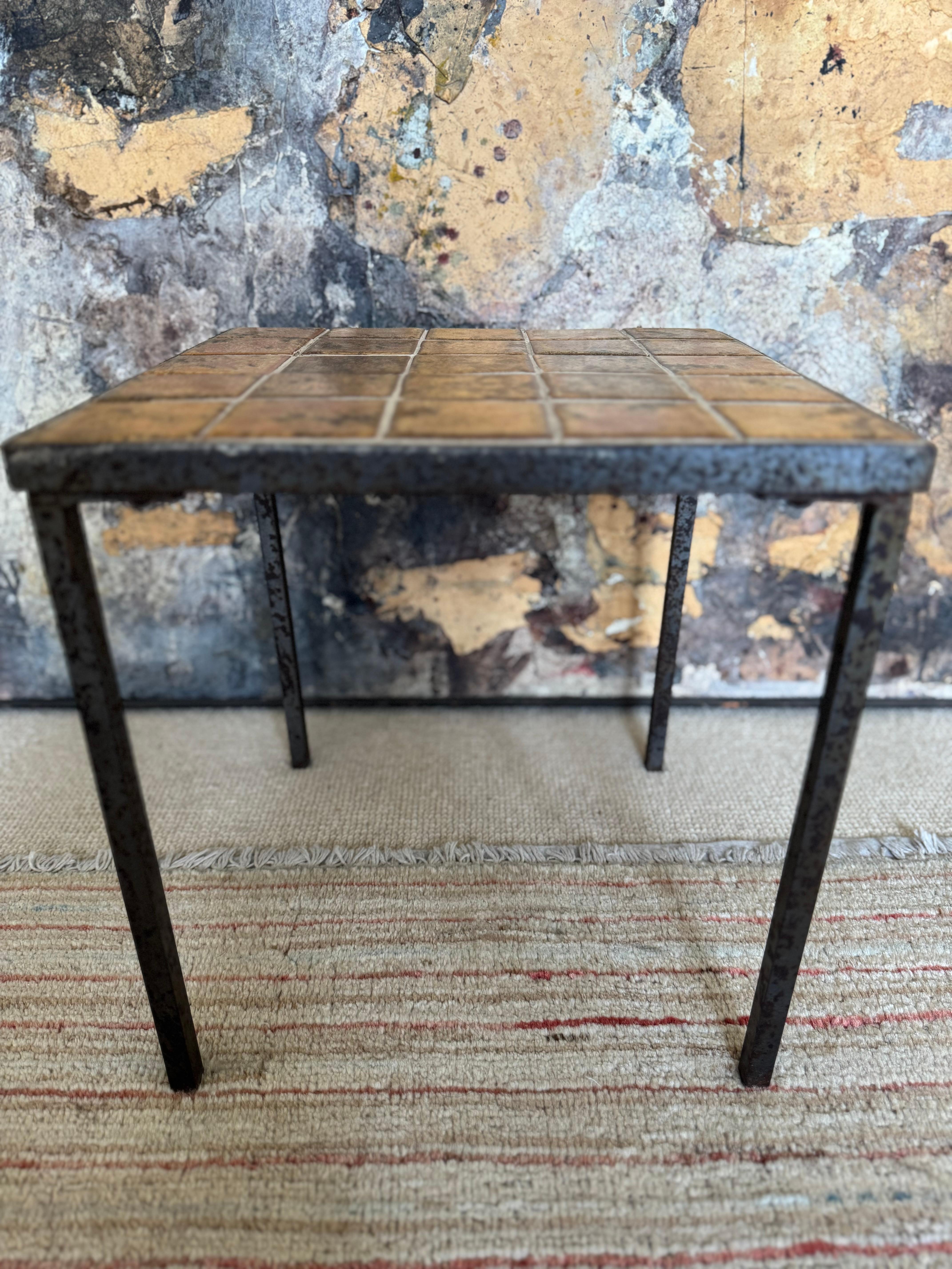 French small iron and ceramic tiled topped side table. Wear conducive to age. Small bend to one leg but does not affect the stability of the table. Great character and look. 