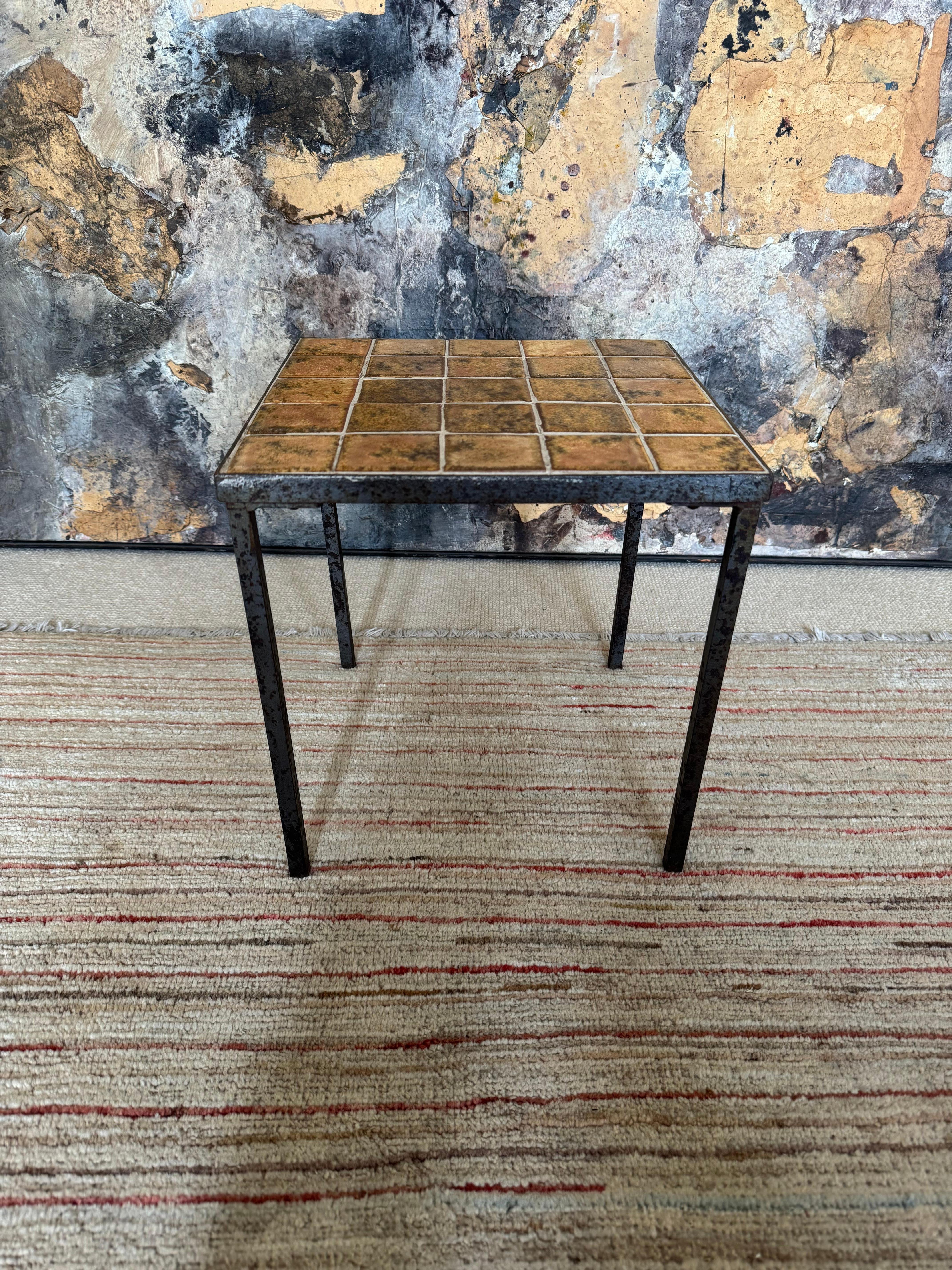 Petite table d'appoint française en fer et céramique. Usure liée à l'âge. Petite déformation d'un pied qui n'affecte pas la stabilité de la table. Un caractère et une allure remarquables. 