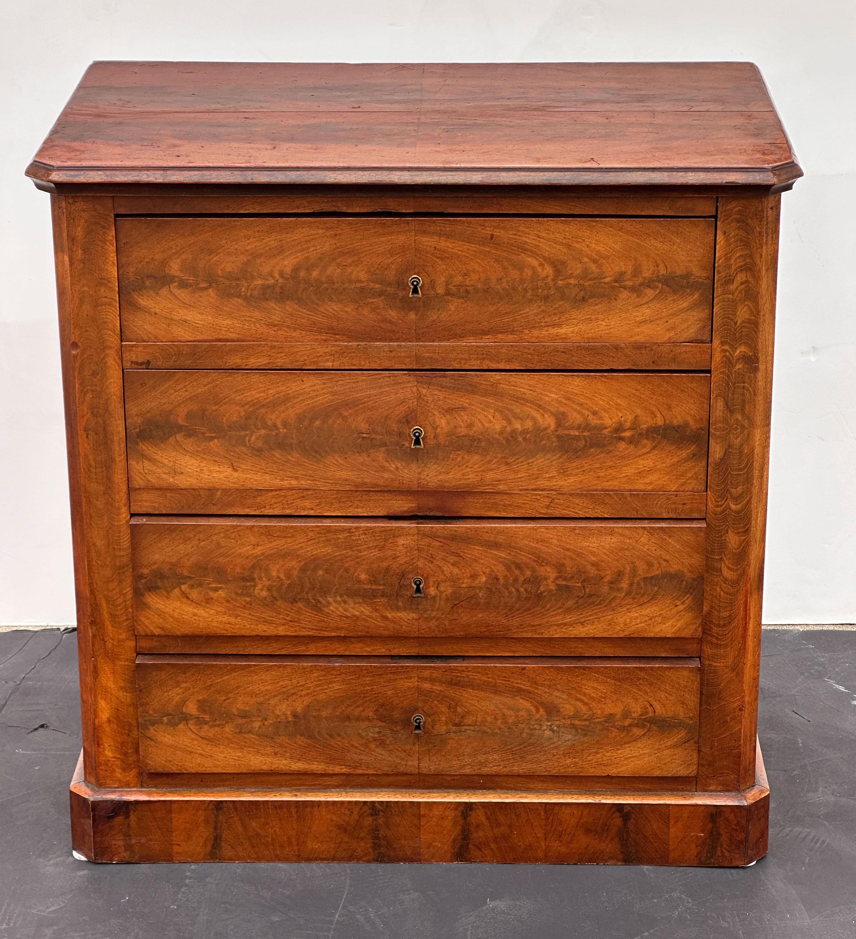 Un'elegante cassettiera o comodino francese in mogano a fiamma, con un piano sagomato su un fregio di quattro cassetti con chiave - con belle impiallacciature per il piano, i lati e in particolare i frontali dei cassetti che creano un'elegante